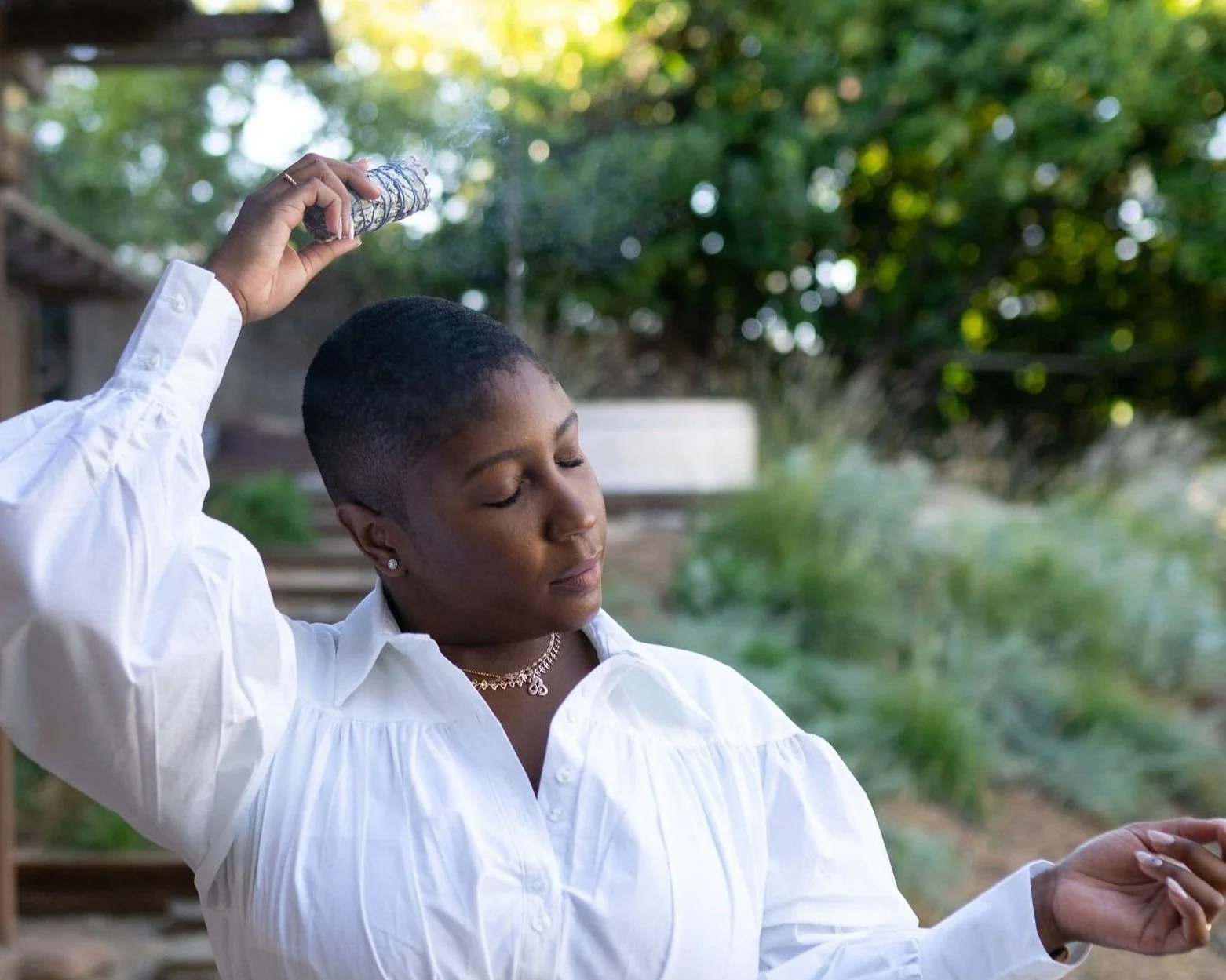 Jewelle looking at peace holding sage