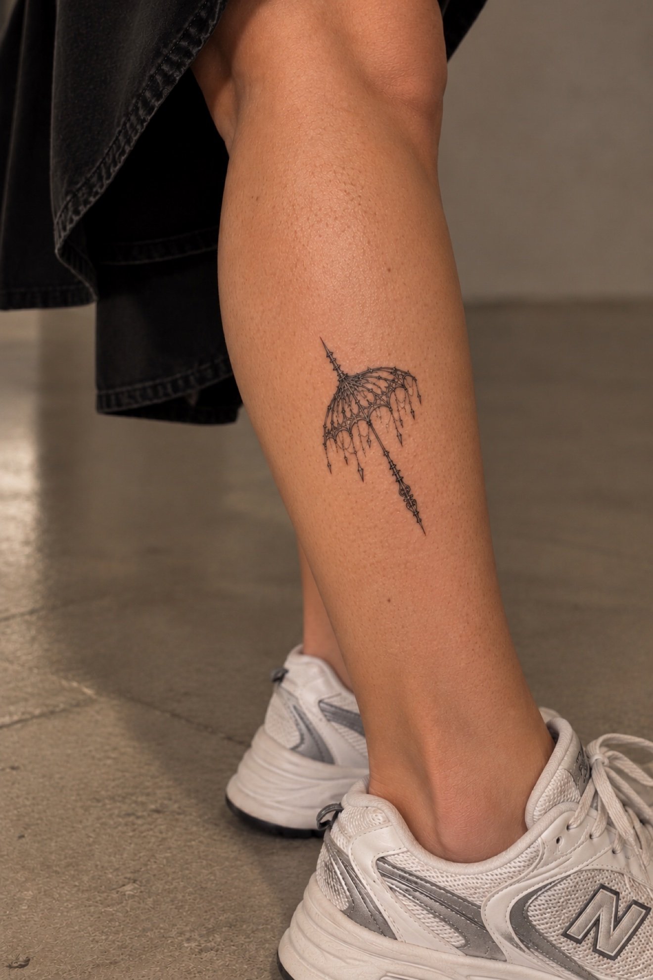 Ornamental umbrella tattoo on calf at Studio Vanassa in Edmonton