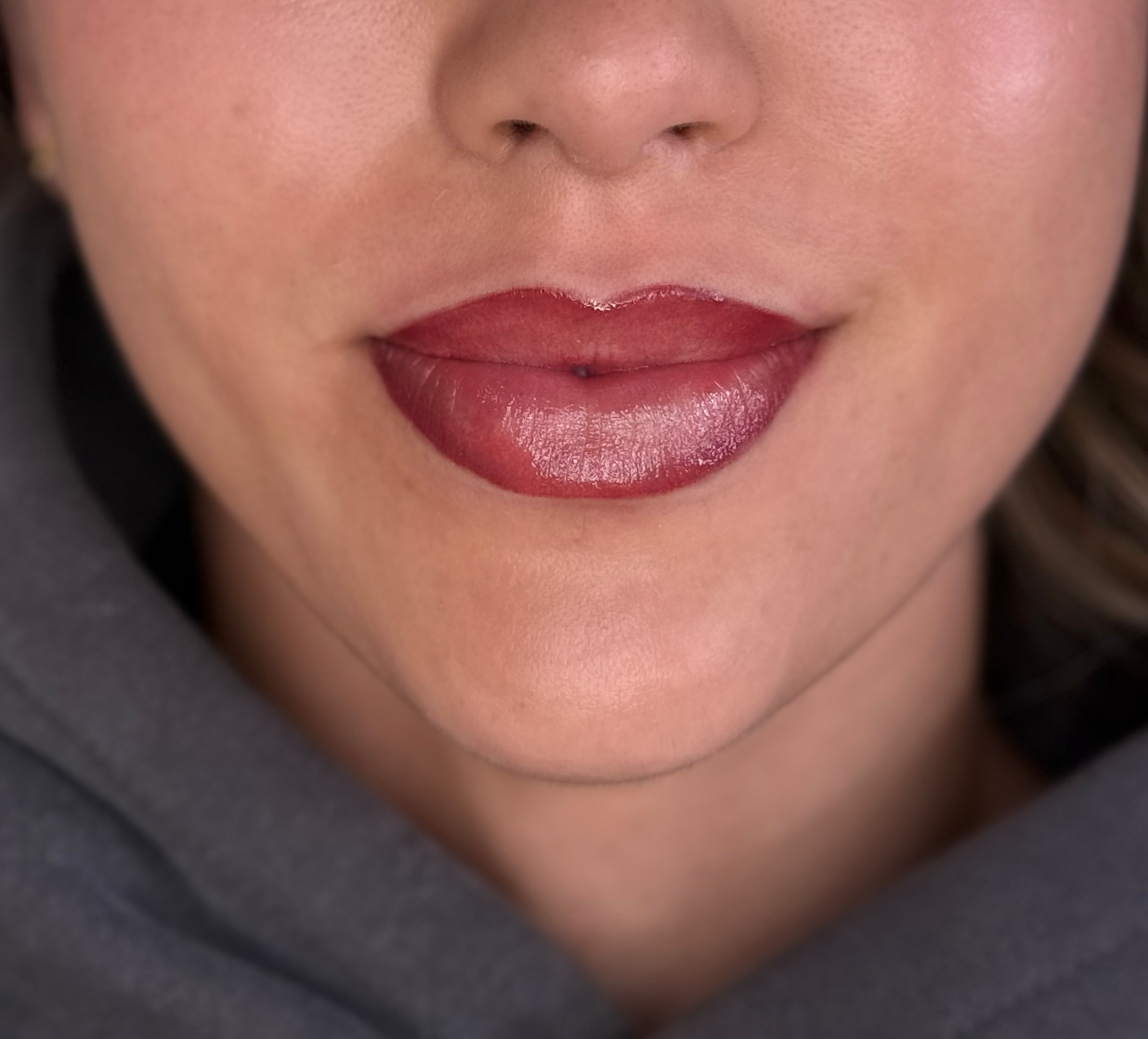 Close-up of a person's face focusing on the nose and lips, with smooth skin and natural makeup.