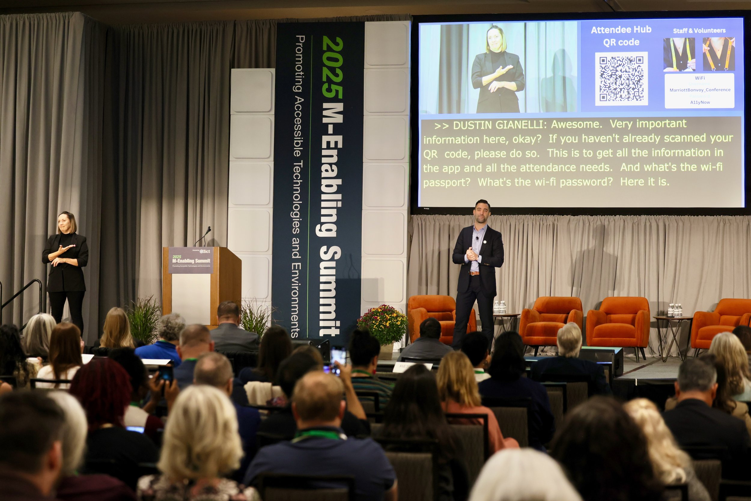 A photo of Dustin on a stage in front of 500+ people (most are seen in the image)