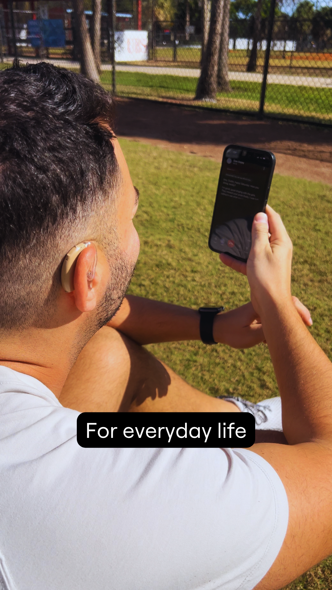 Dustin using his iPhone for a captioned phone call. Text says, "For everyday life"