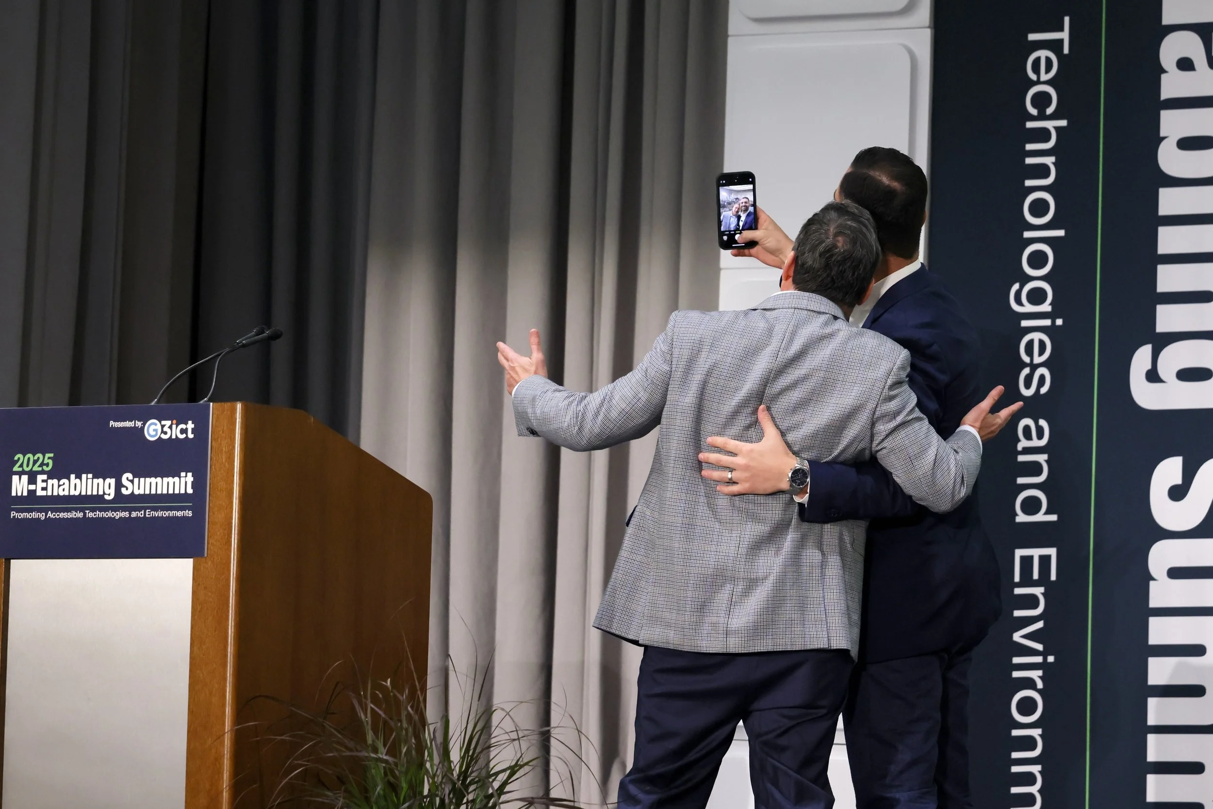 A photo of Dustin and the organizer of the event taking a selfie on stage in front of 500+ people (not seen in the photo)