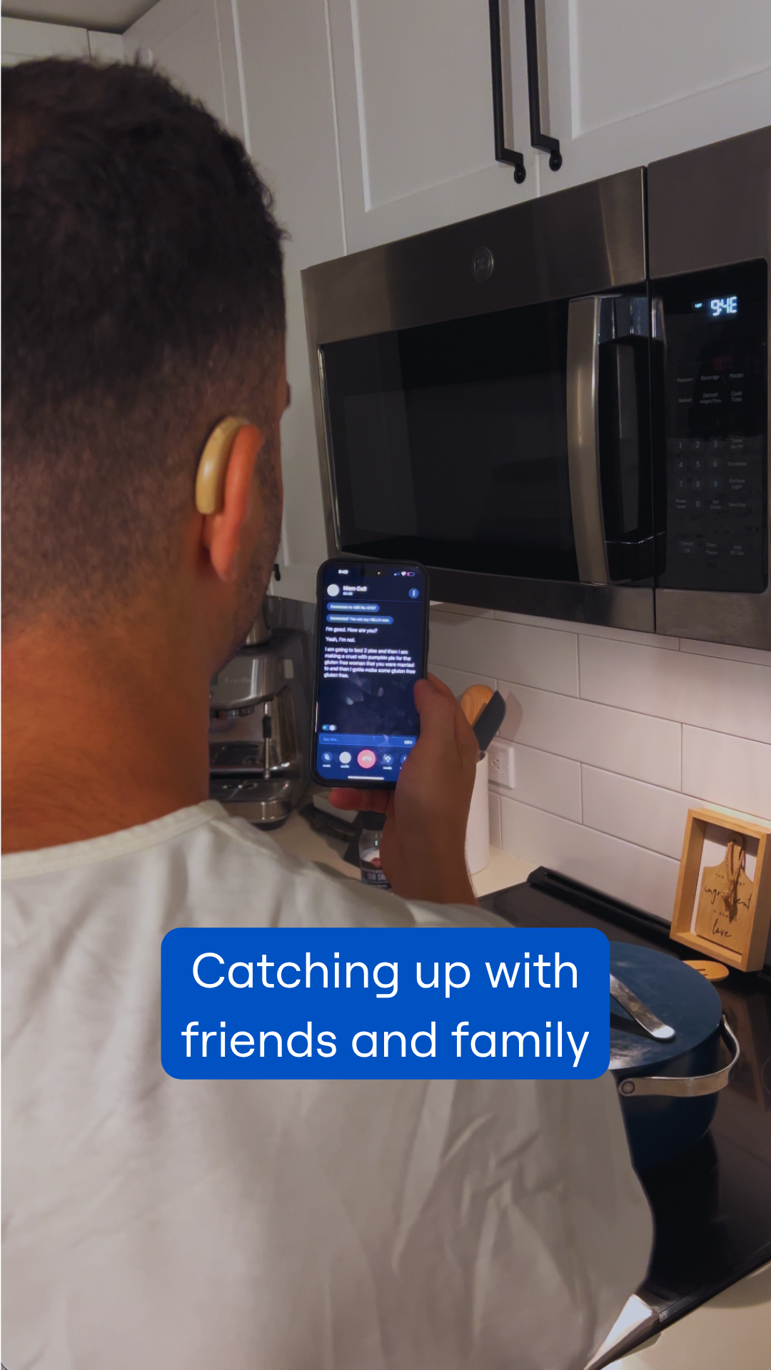 Dustin using his iPhone for a captioned phone call. Text says, "Catching up with friends and family"