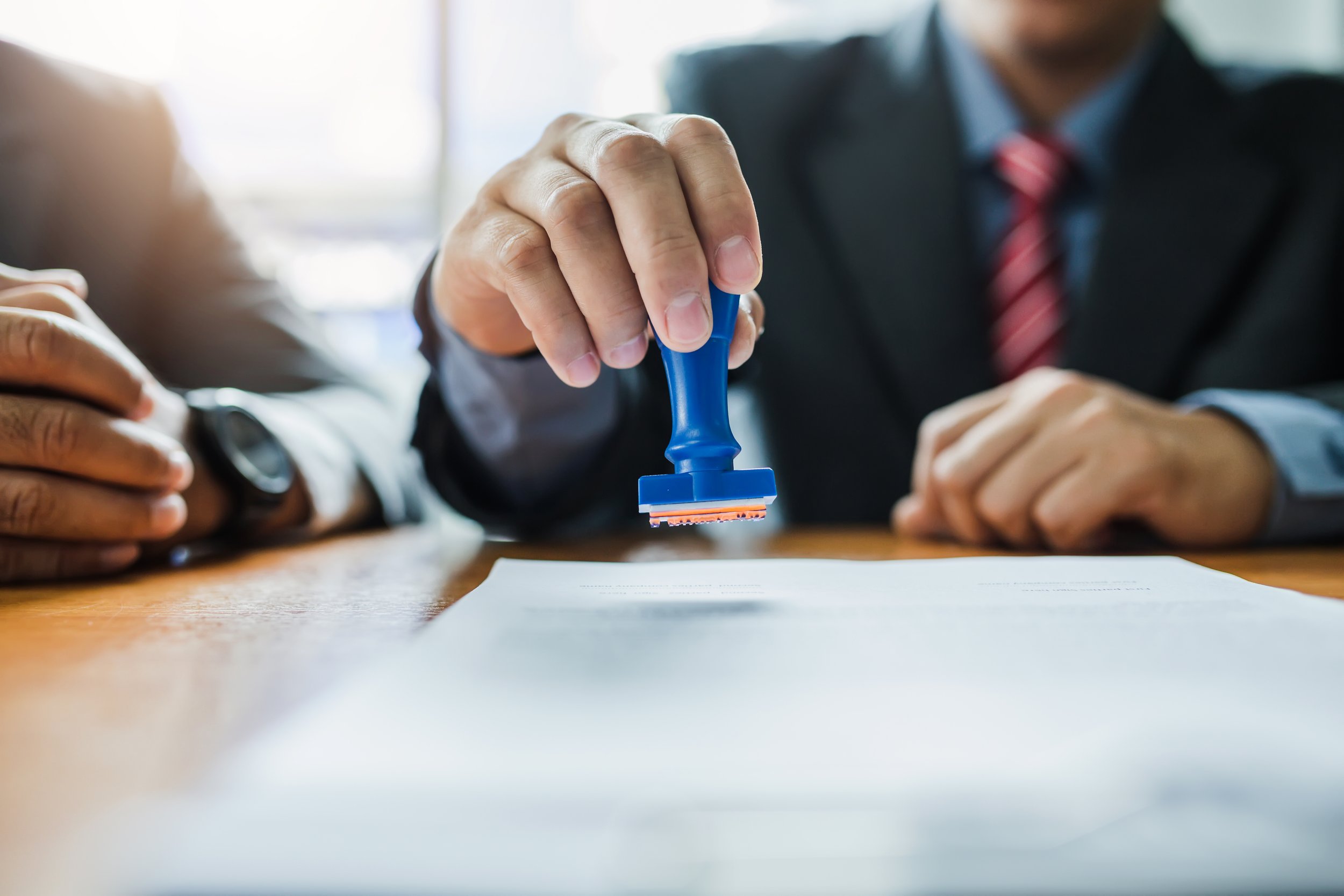 Businessman stamping with approved stamp on paper business contr (Copy)