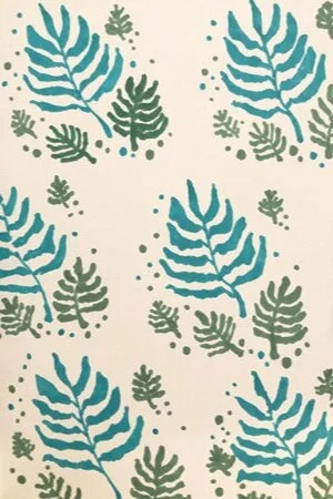 Pattern of teal and green tropical leaves with small dots on a light background.