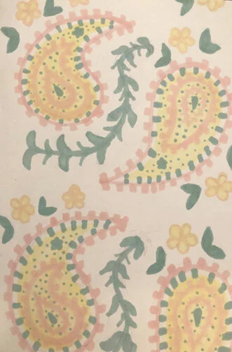 A floral pattern featuring yellow paisley shapes, green leaves, and small yellow flowers on a light background.