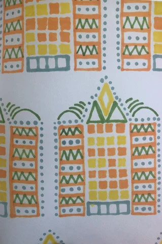 Decorative pattern with geometric shapes in yellow, orange, green, and blue, arranged symmetrically.