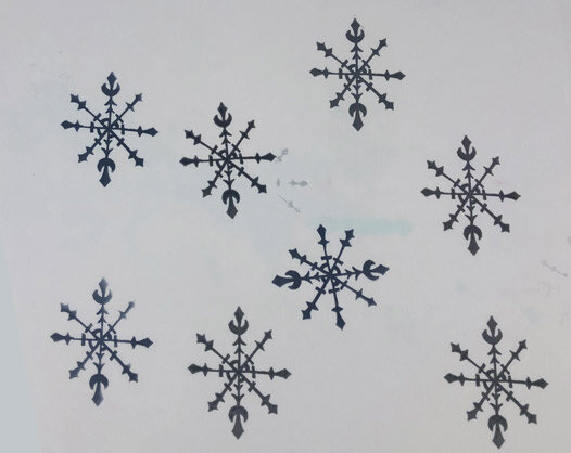 Seven black snowflake shapes evenly spaced on a white background.
