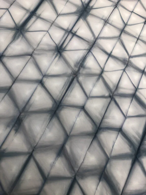 Close-up of a glass and metal building exterior with geometric patterns.