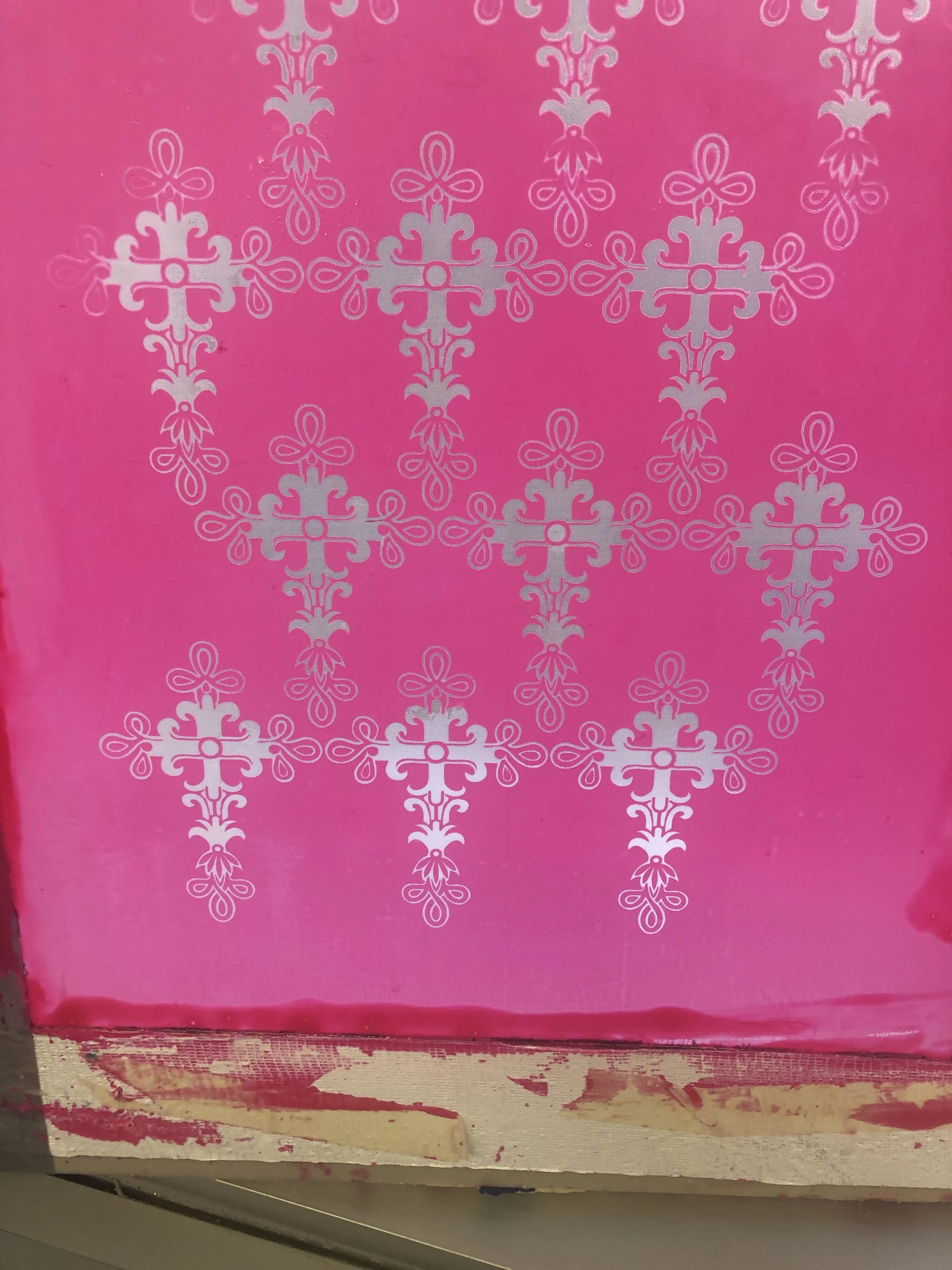 Pink surface decorated with white intricate snowflake-like patterns.