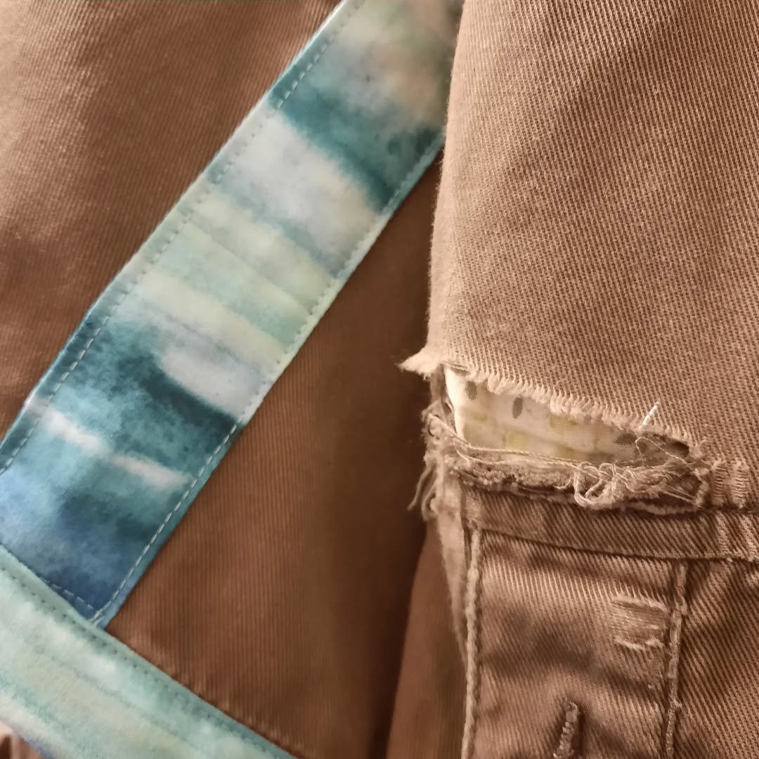 A little bit more mending. There are some more strips of fabric today to seal up the fraying jacket edge. It's been a little bit like adding binding to a quilt.

Image Description: First image shows a close up of a brown jacket, there is a tear in th