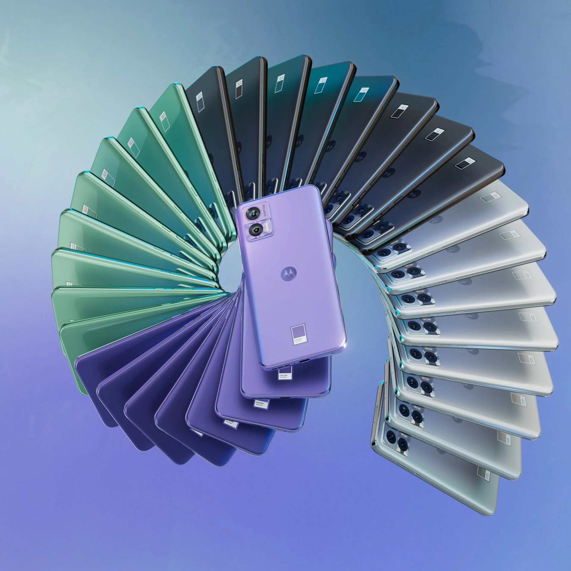A display of multiple Motorola smartphones arranged in a spiral, showcasing a range of colors from pastel purple to green, blue, black, and silver, with a pastel purple phone in the center.