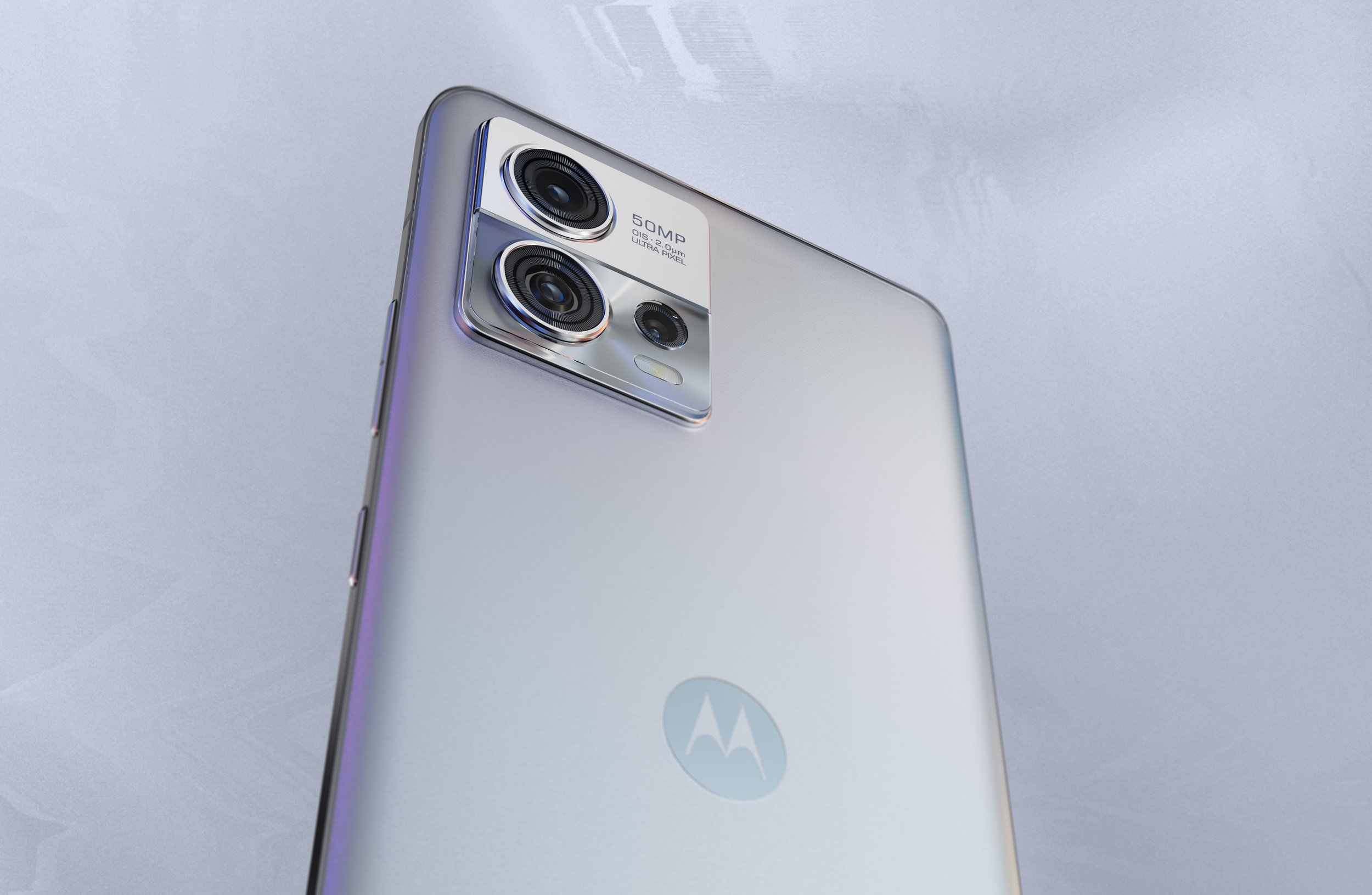 Close-up of a silver Motorola smartphone showing the back with a triple camera setup and the Motorola logo.