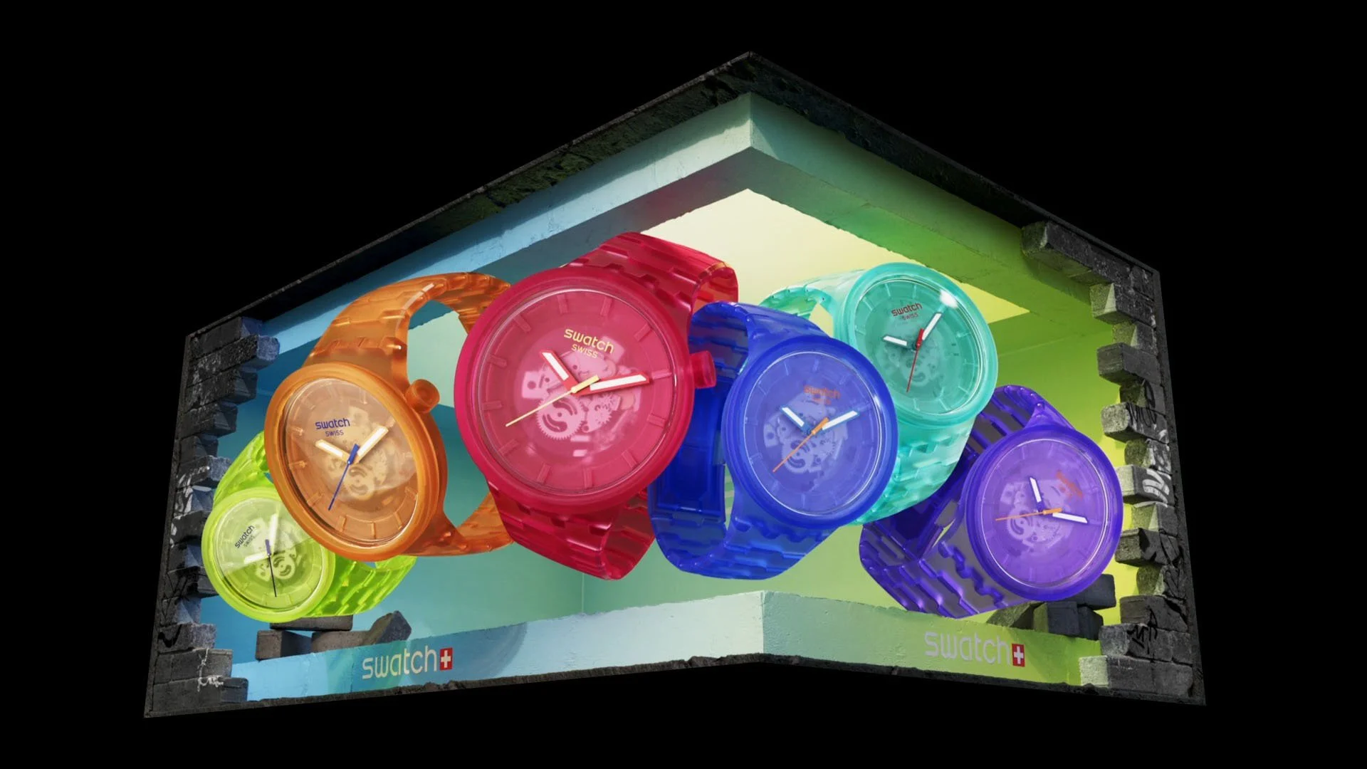 Colorful Swatch watches on display in a glass case with a black background.