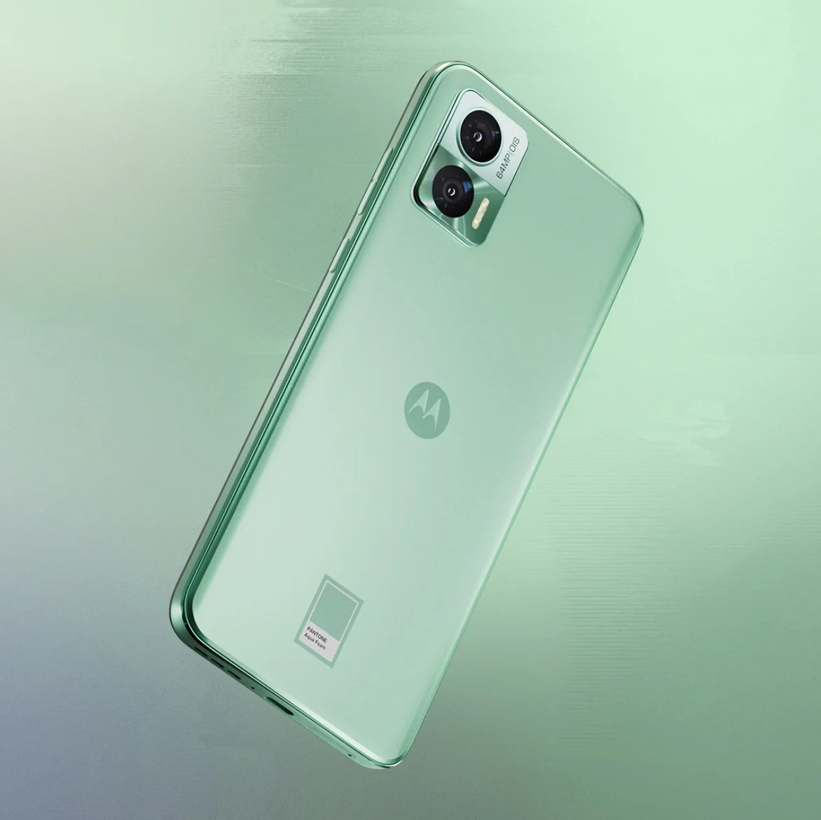 A light green Motorola smartphone with a dual camera, LED flash, and a logo on the back, placed on a matching green background.