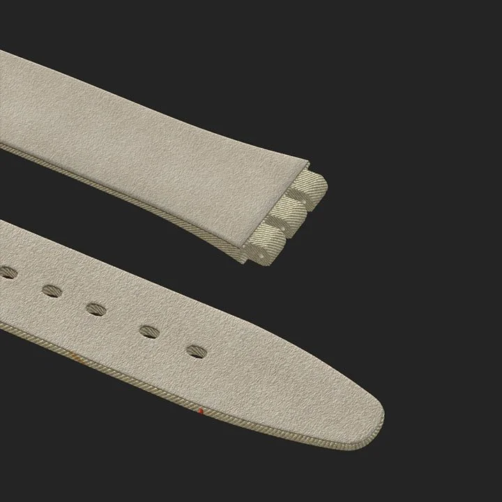 Close-up of a beige watch strap with multiple adjustable holes, placed on a black surface.