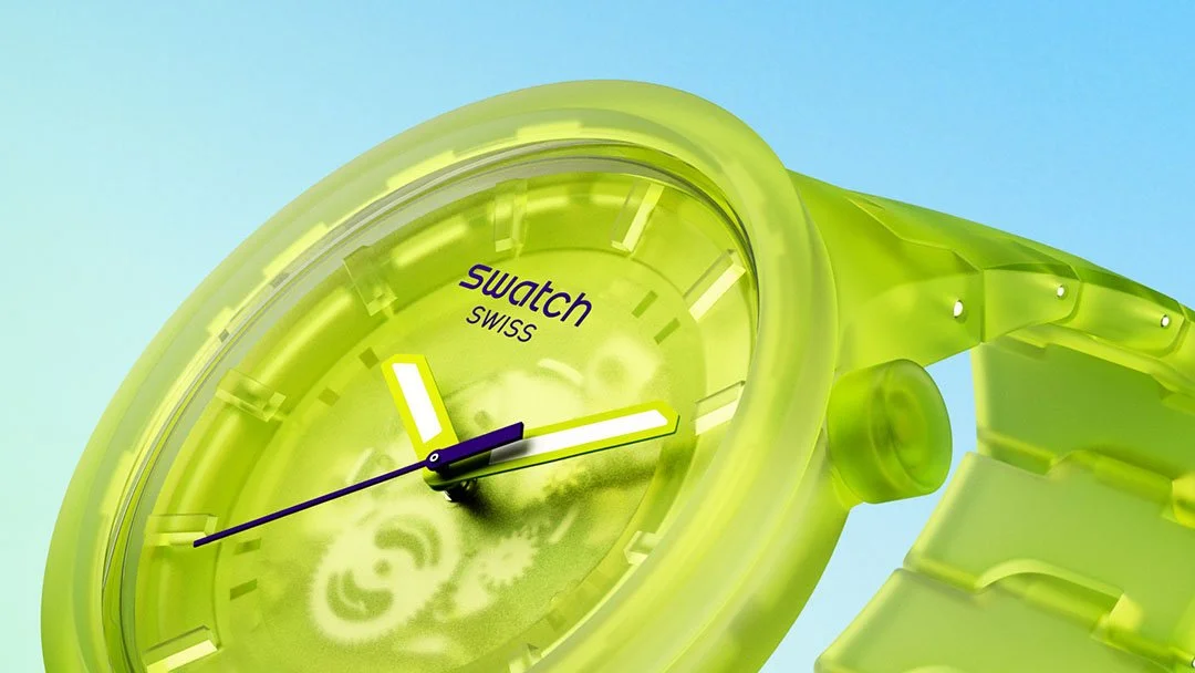 Close-up of a neon green Swatch wristwatch with a translucent band and face, yellow hour markers, and the time showing approximately 3:10. The background is a clear blue sky.