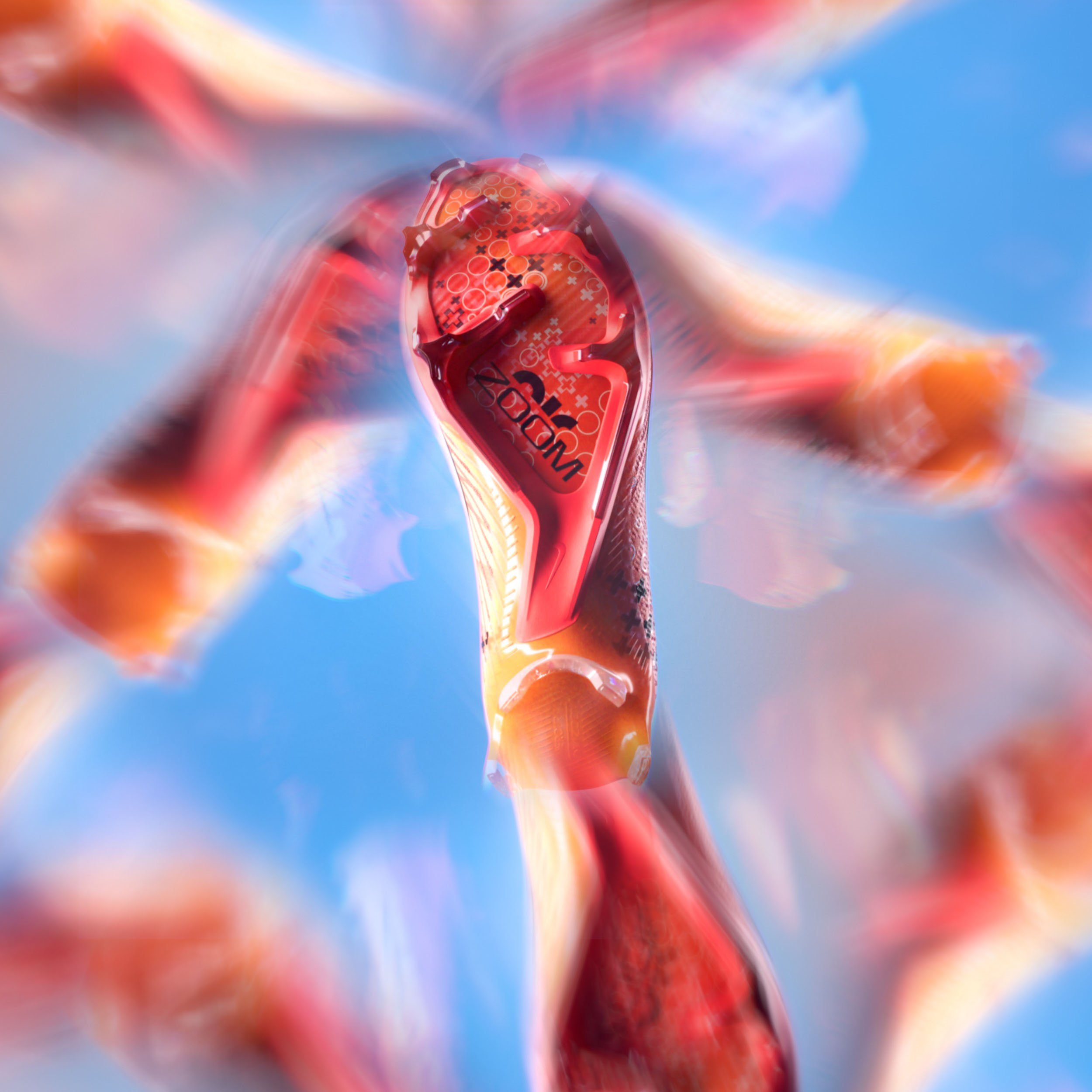 A close-up of a wine gum candy with a red and orange swirl pattern, set against a bright blue sky background.