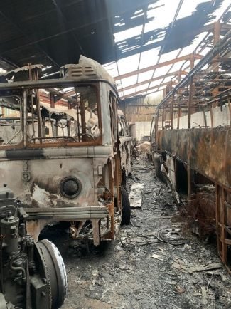 Warehouse interior and two busses destroyed by fire.jpg