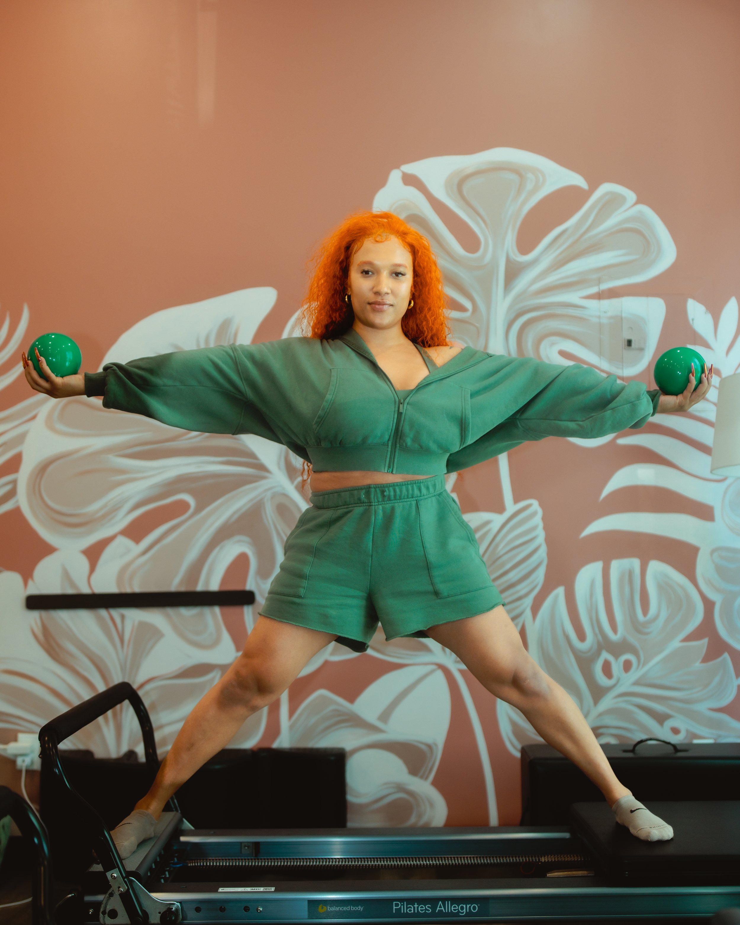 DJ on the Reformer in a green outfit.