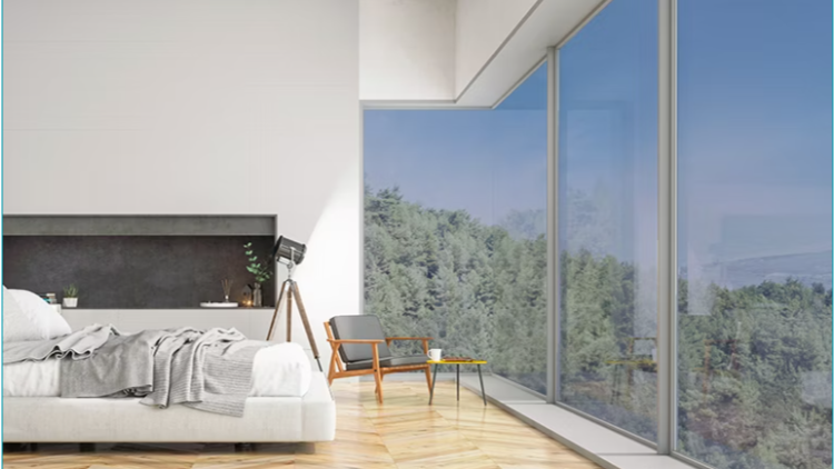 A modern bedroom with a large floor-to-ceiling window overlooking a lush green landscape, a white bed with grey bedding, and a wooden chair with a small table.