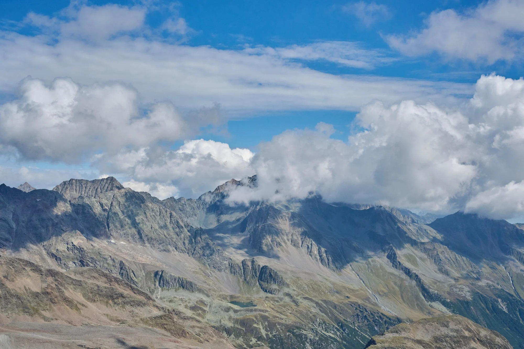 Scenic view of rugged mountain range under partly cloudy sky