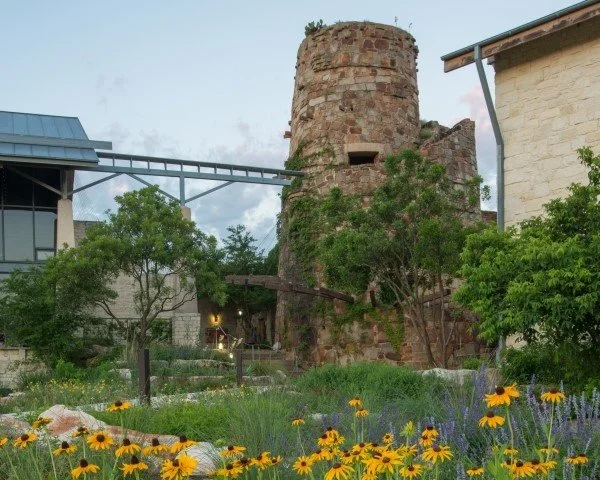 A stone tower surrounded by wildflowers