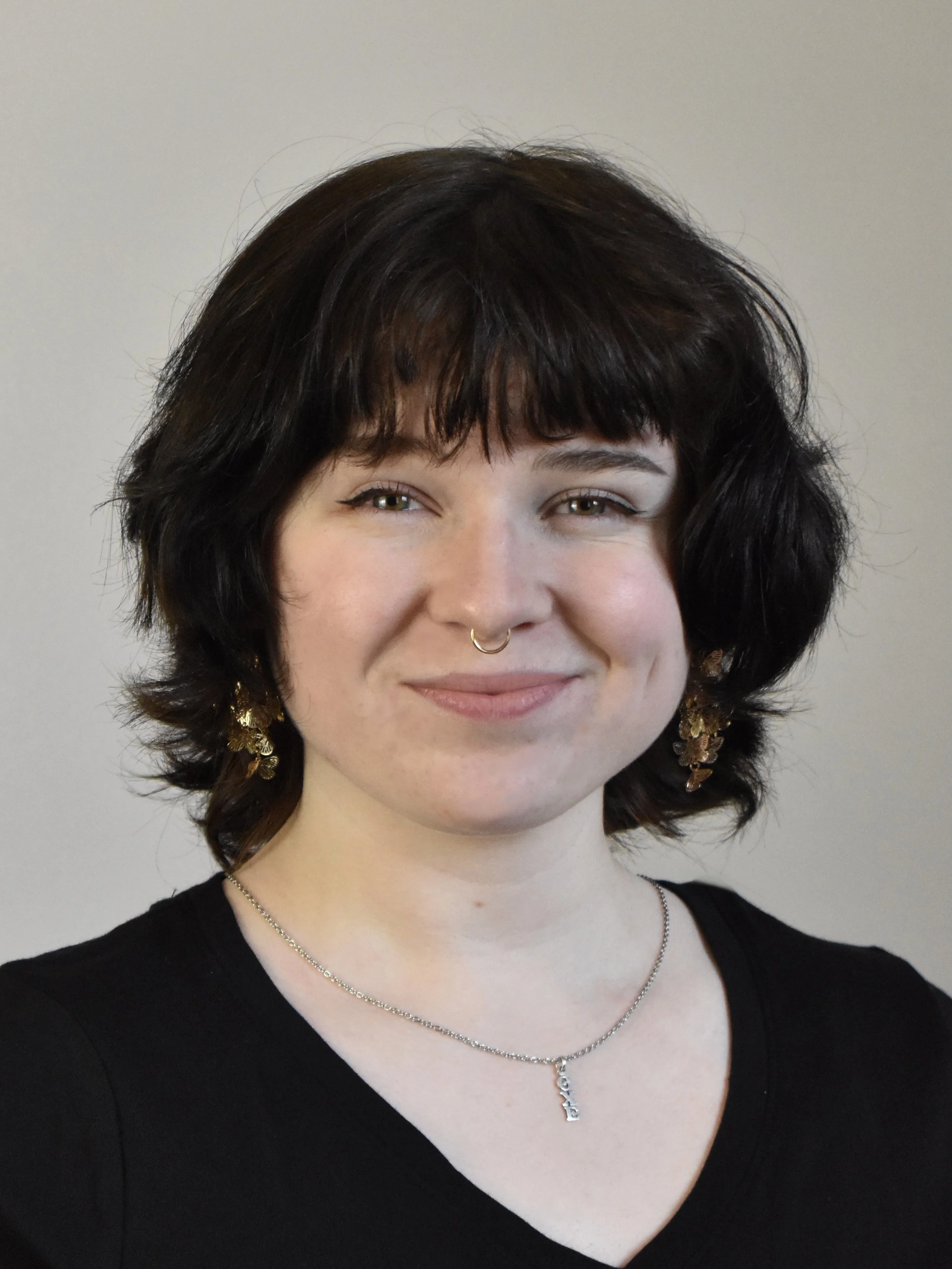 A young woman with black hair smiling softly.