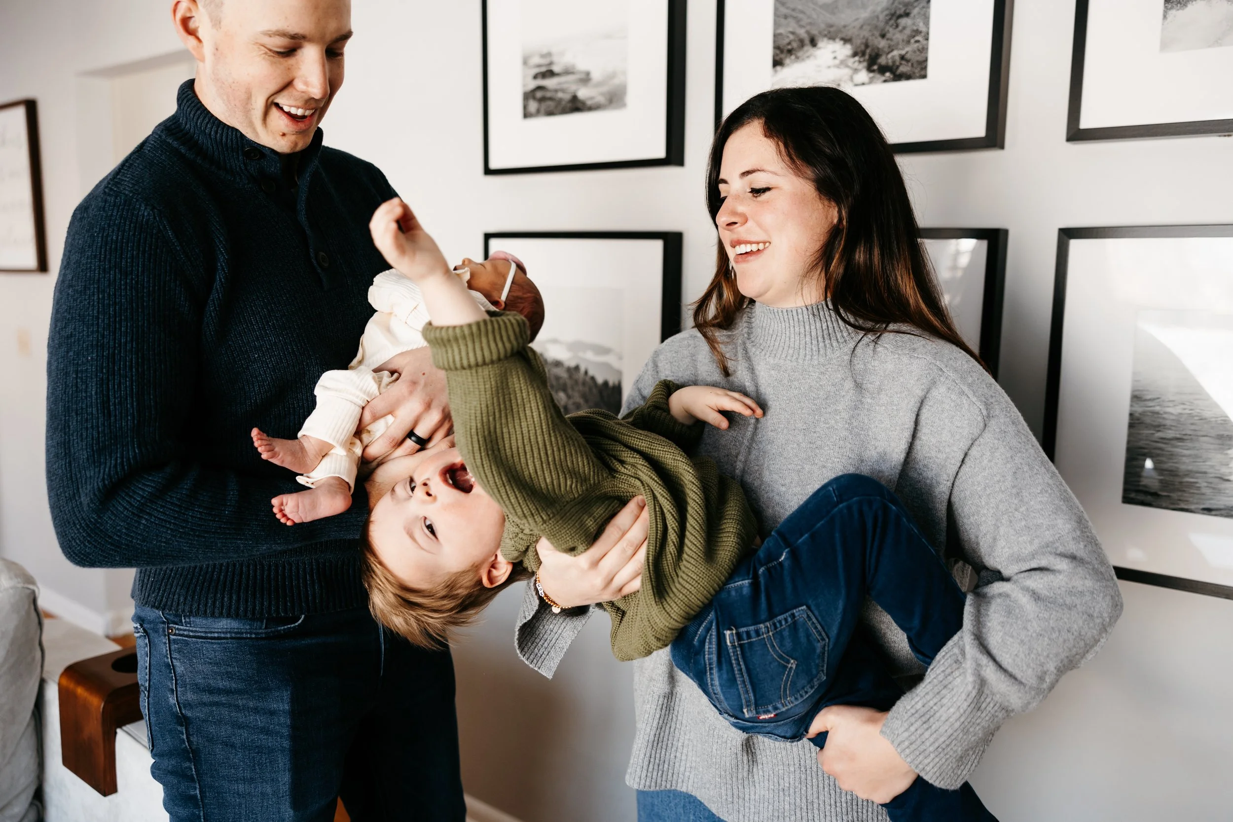Parents hold their toddler and newborn for family photo