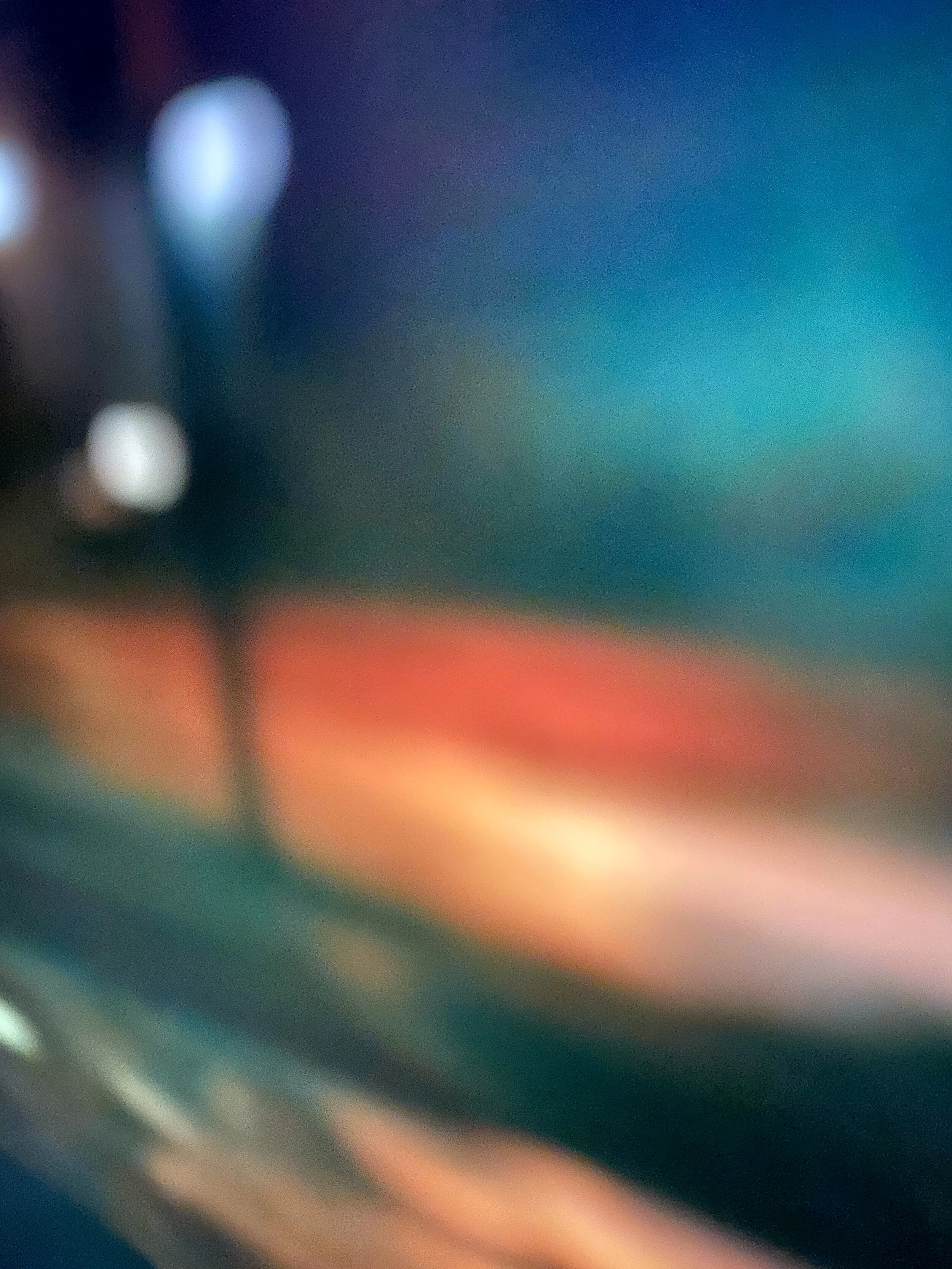 Blurred, colorful abstract background with shades of blue, orange, green, and black.