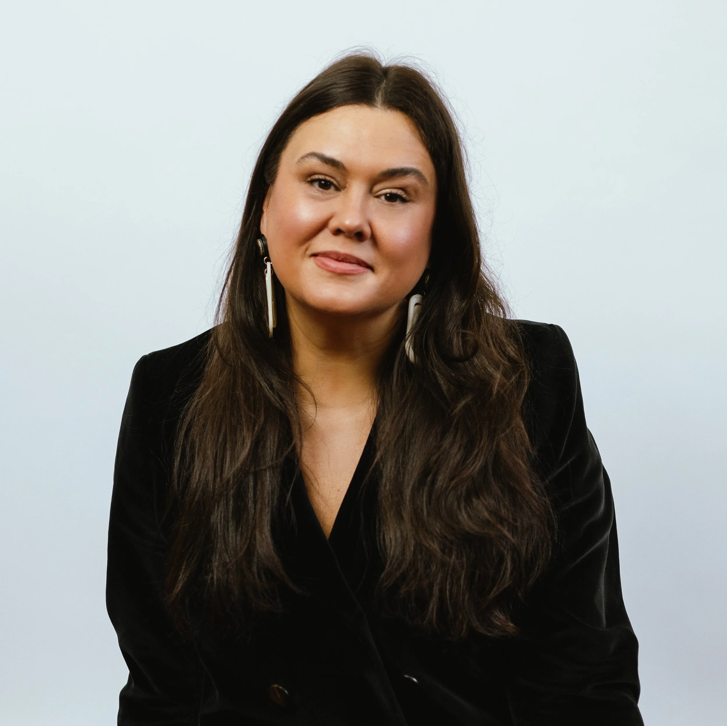 Woman with long dark hair in a black blazer