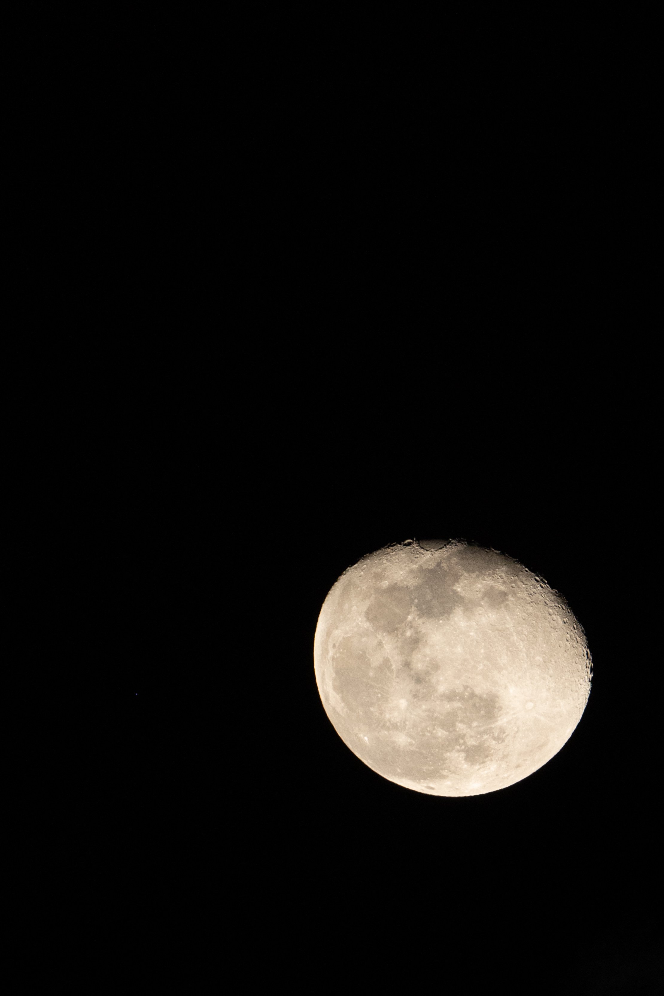 Close-up photograph of the moon in the night sky with a dark background.