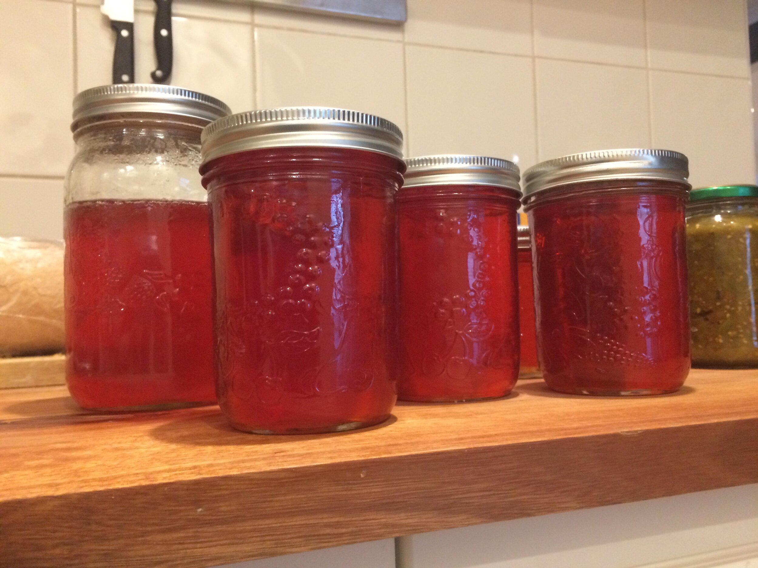 Jars of bright red clear quince jelly