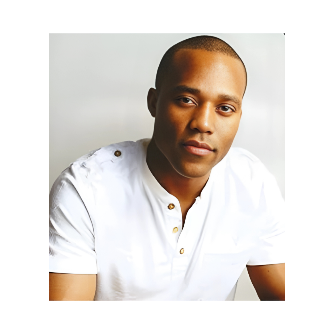 A young man with short hair wearing a white shirt with gold buttons, looking at the camera against a light background.