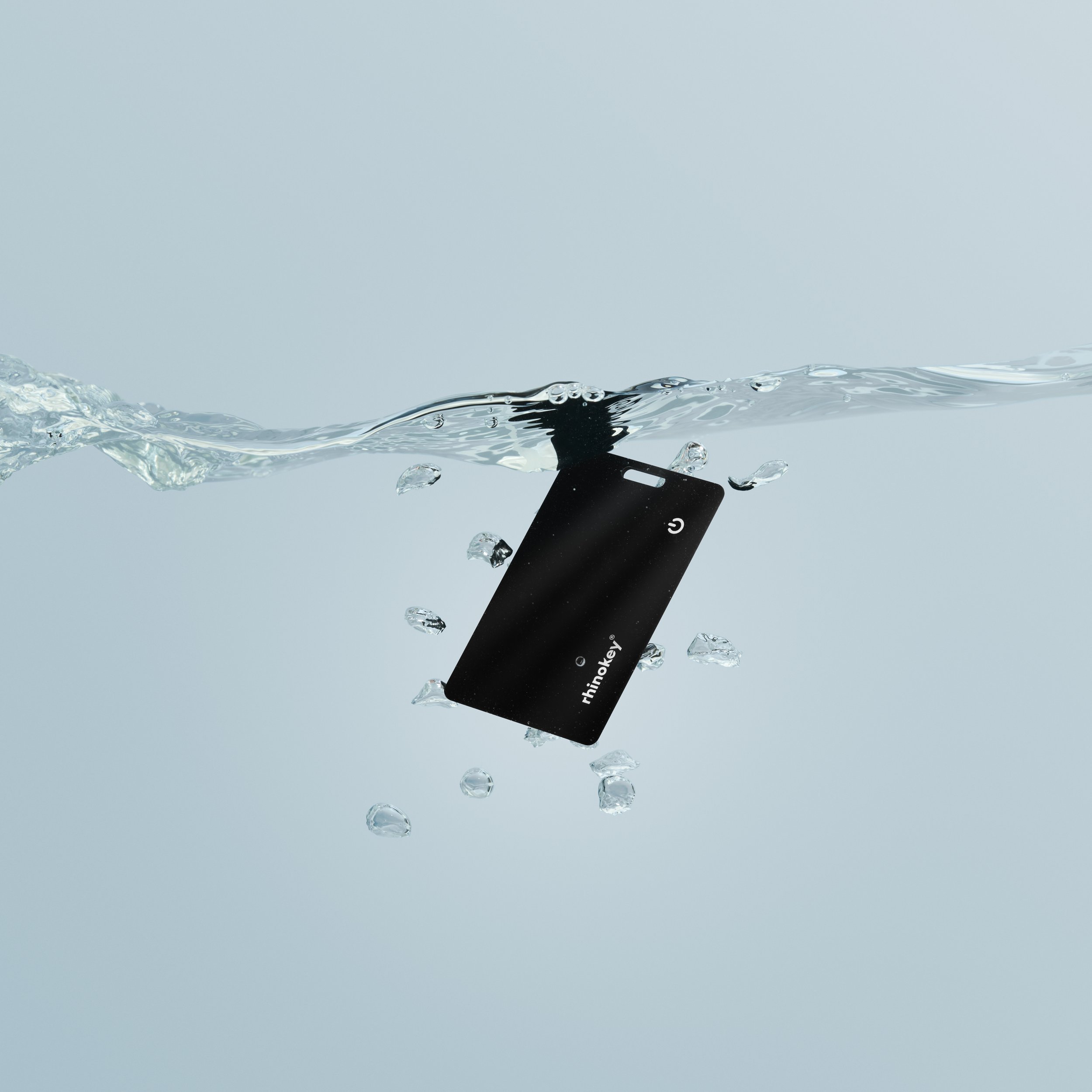 A black smartcard with the brand name 'Rhinokey' floating in water with bubbles around it. Product Photography. Creative Photography. eCommerce Photography.
