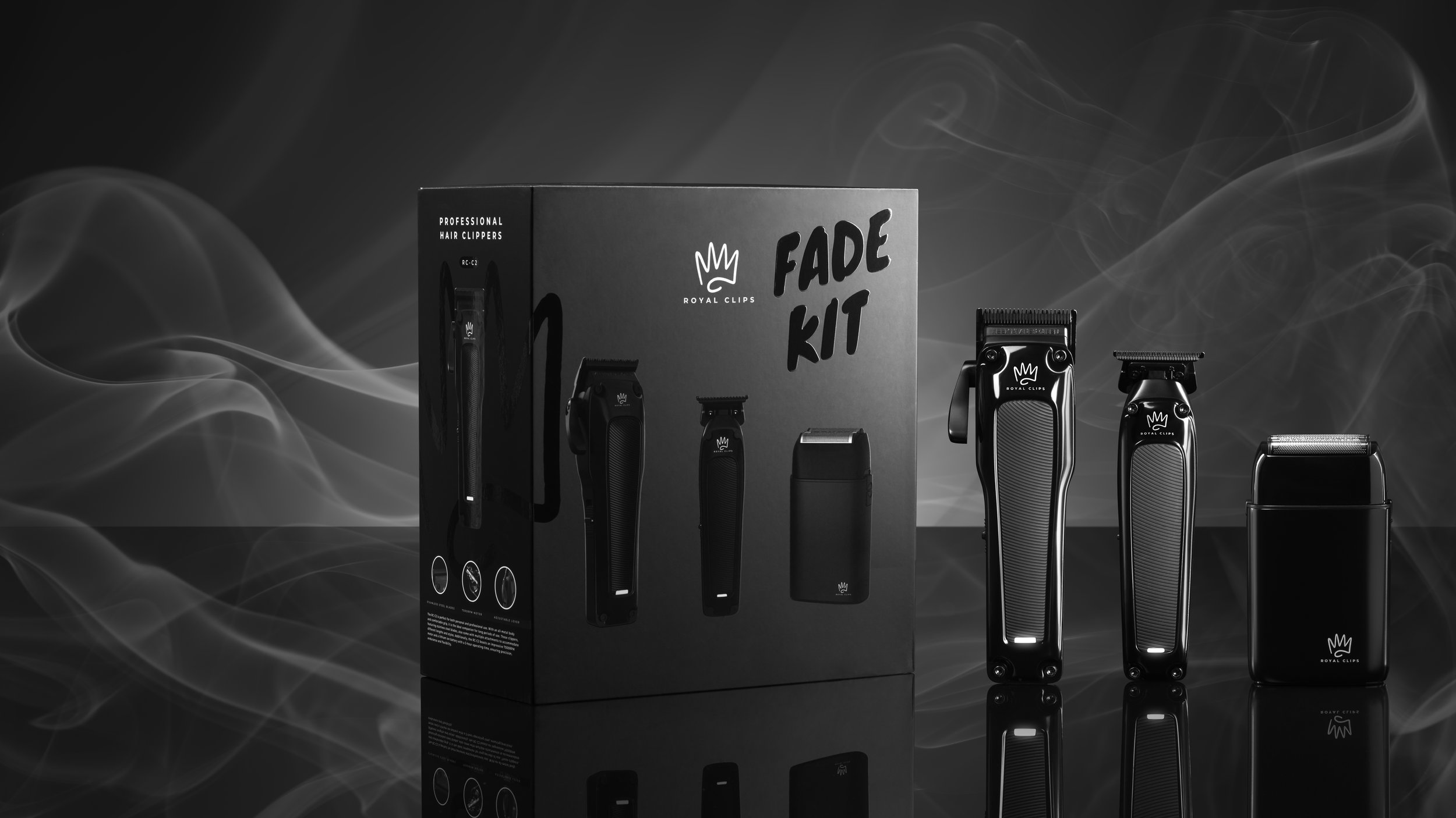Set of professional hair clippers and trimmers with packaging box labeled "Fade Kit" on a black reflective surface, with smoky background.