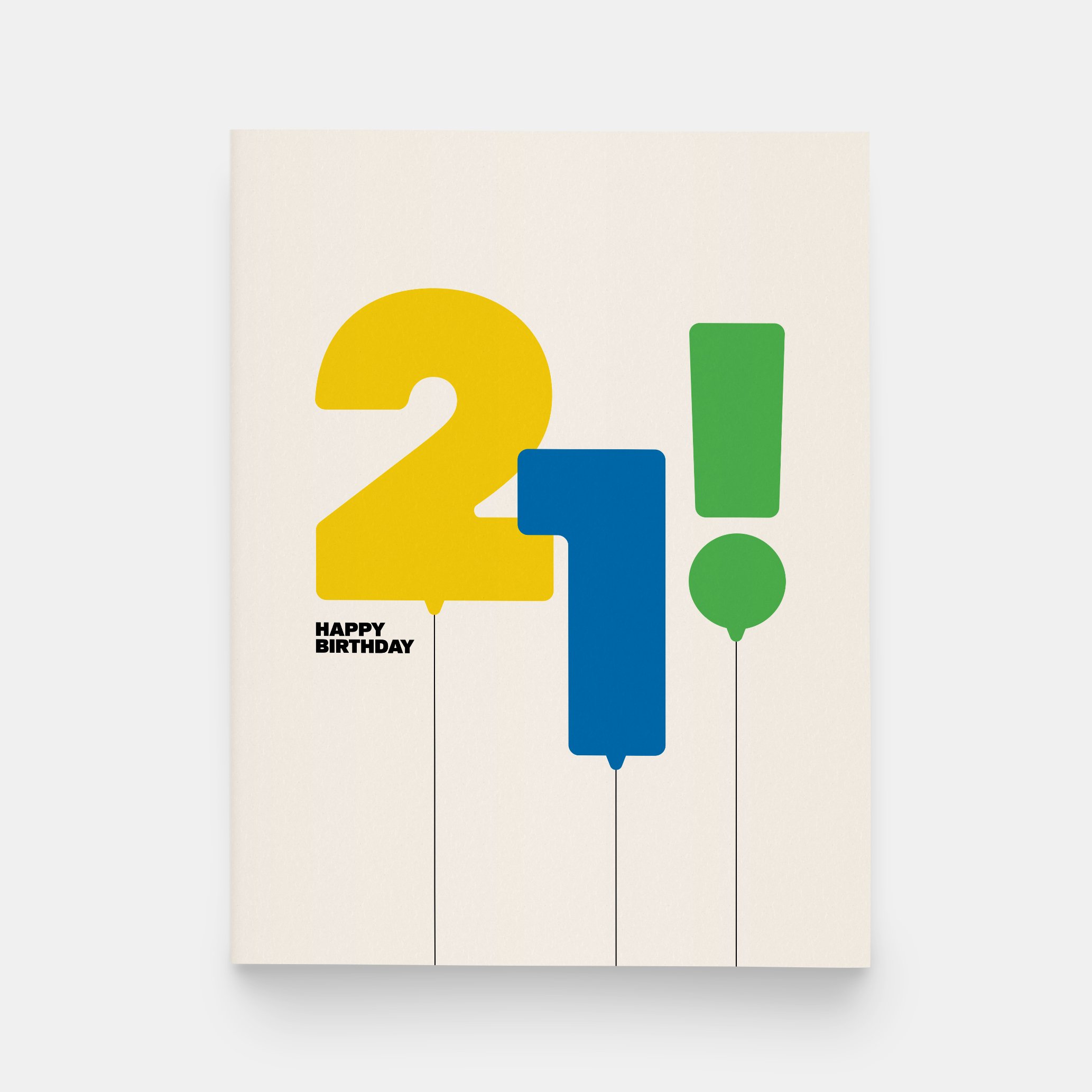 A creme greeting card has yellow, blue, and green balloons in the shape of "21!". In small black text, "Happy Birthday" is written at the bottom left hand corner.