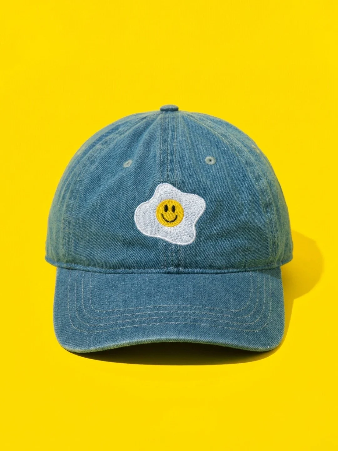 not your average dad hat. embroidered fried egg. tiny smile. soft-washed denim. adorably perfect.