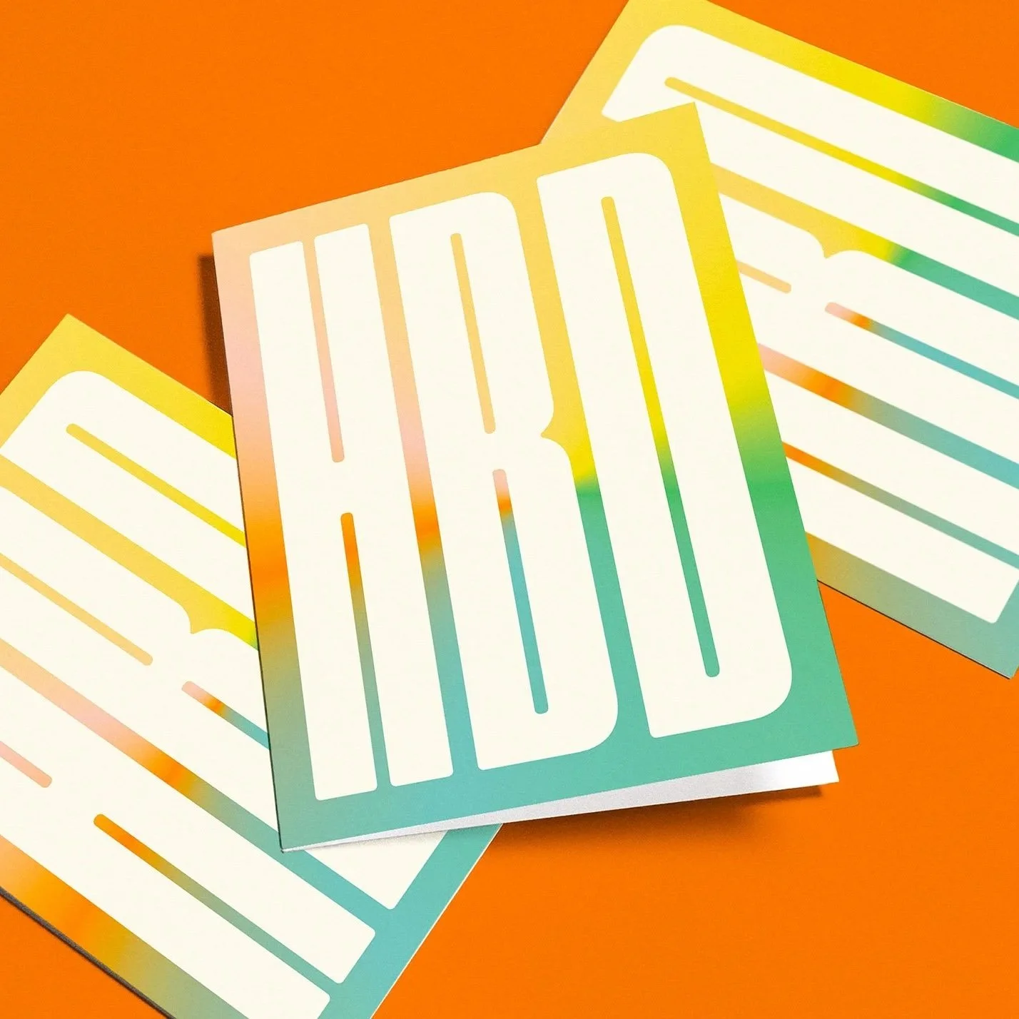 Colorful stickers on an orange background, with the word 'HBD' in bold white letters.