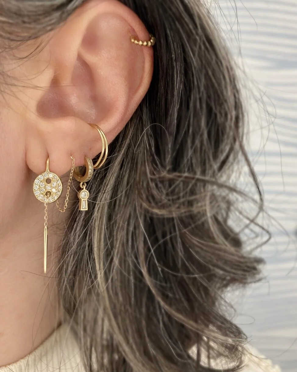 Literally a threader, the button earring here is pulled through a piercing and then a buttonhole; made for you to play with as you see fit. #play  #finejewelry #needle #button #threader