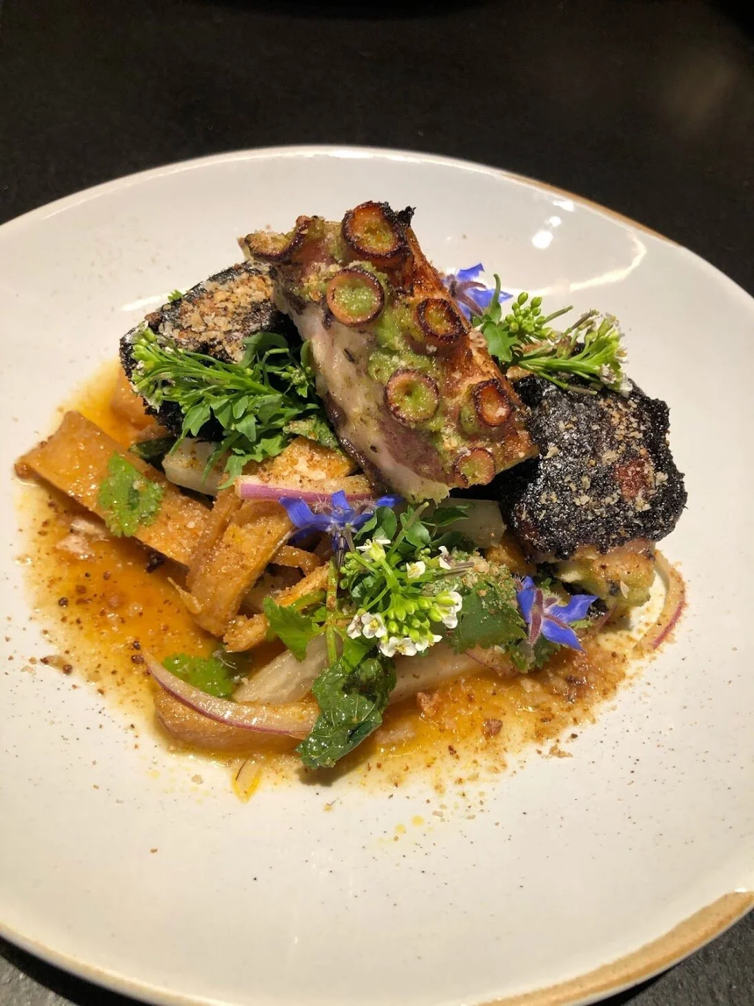 Grilled Octopus with daikon salad, 
Herbs and curry vinaigrette.