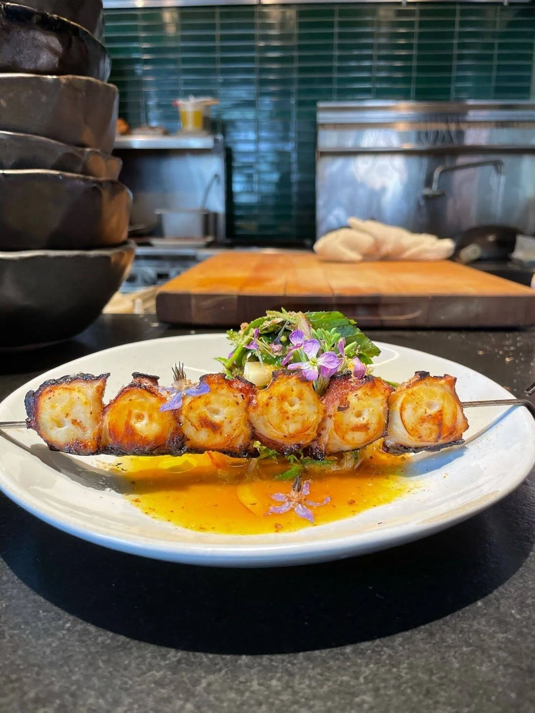 Grilled Octopus, daikon salad, 
and Herbs, with curry vinaigrette.