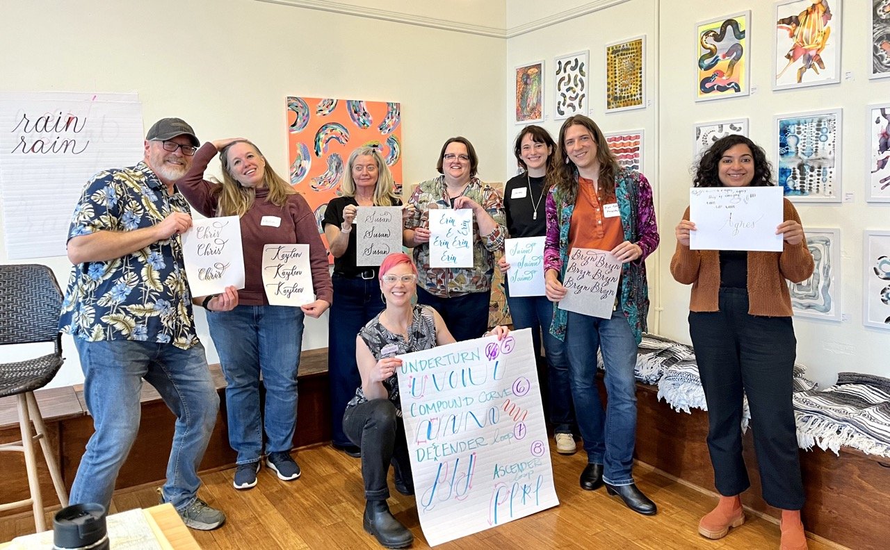 A classroom of smiling adults in art class.
