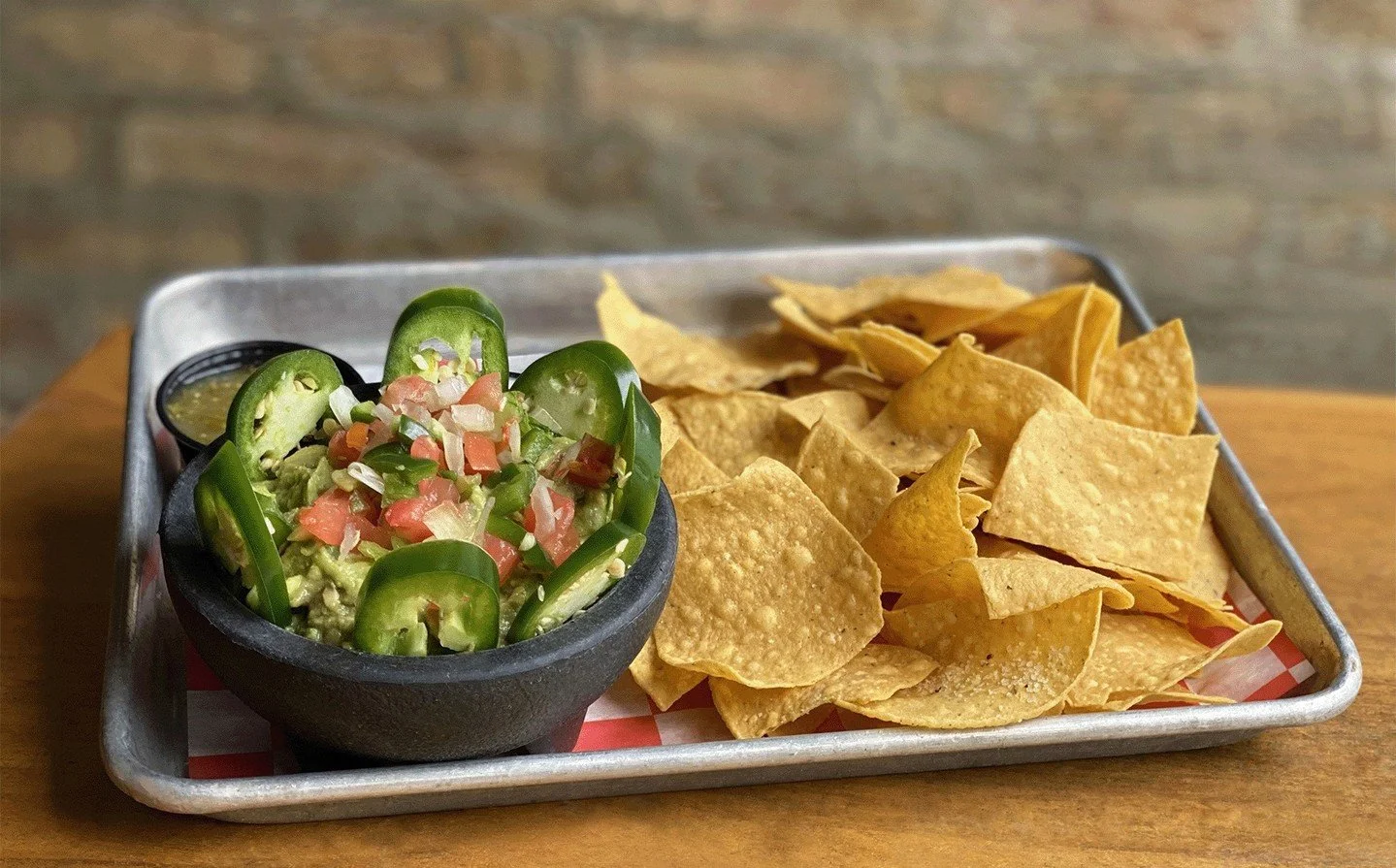 Have you tried our house guacamole? Since today is National Spicy Guacamole Day, what are you waiting for? Our Guac &amp; Chips features handmade guacamole (avocado, onions, jalapeno, tomatoes, cilantro). Garnished with fresh jalapeno + sides of hous