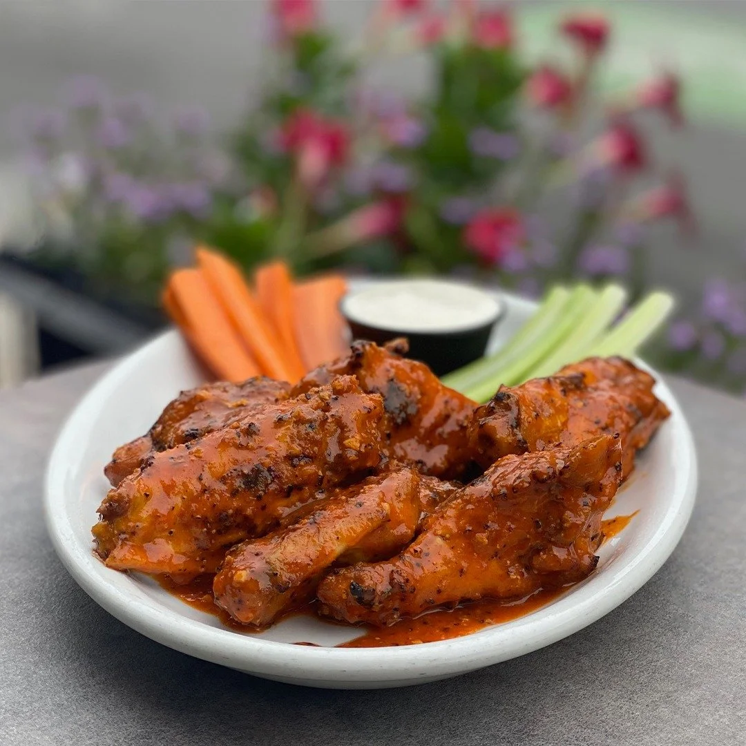 Why yes - wings do taste better al fresco!  Our wings are wood-grilled, not fried, so they are full of smoky flavor. Choose from BBQ, buffalo, lemon pepper, buffalo-&amp;-lemon pepper (pictured), garlic parmesan, jerk, mango habanero, or our ghost pe