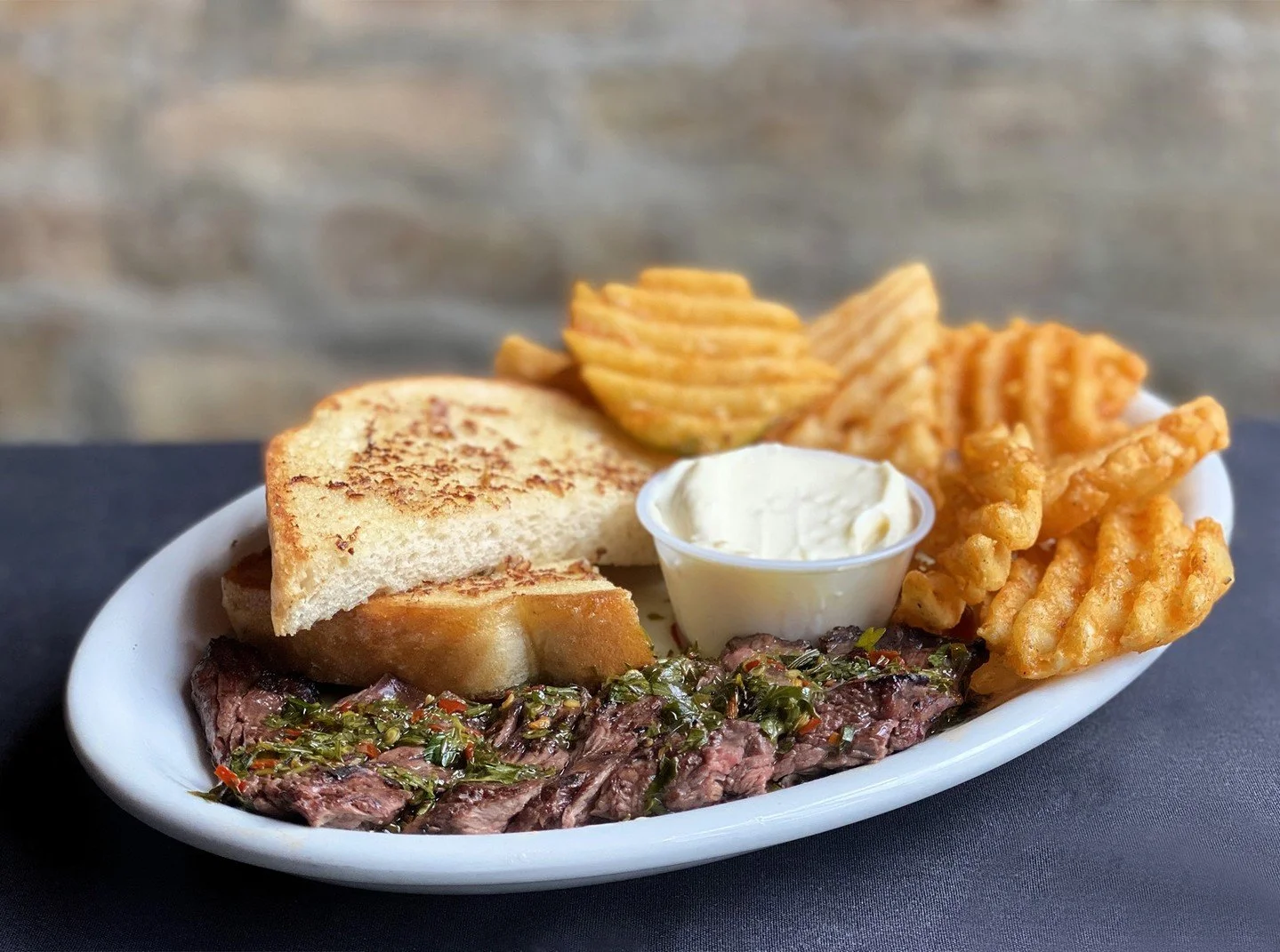 Sunday Supper - what's better than protein-packed steak with a side of spuds? Our Chimichurri Steak entr&eacute;e features a wood-grilled USDA Choice center cut sirloin steak, with house chimichurri sauce, waffle fries, garlic bread and a side of gar