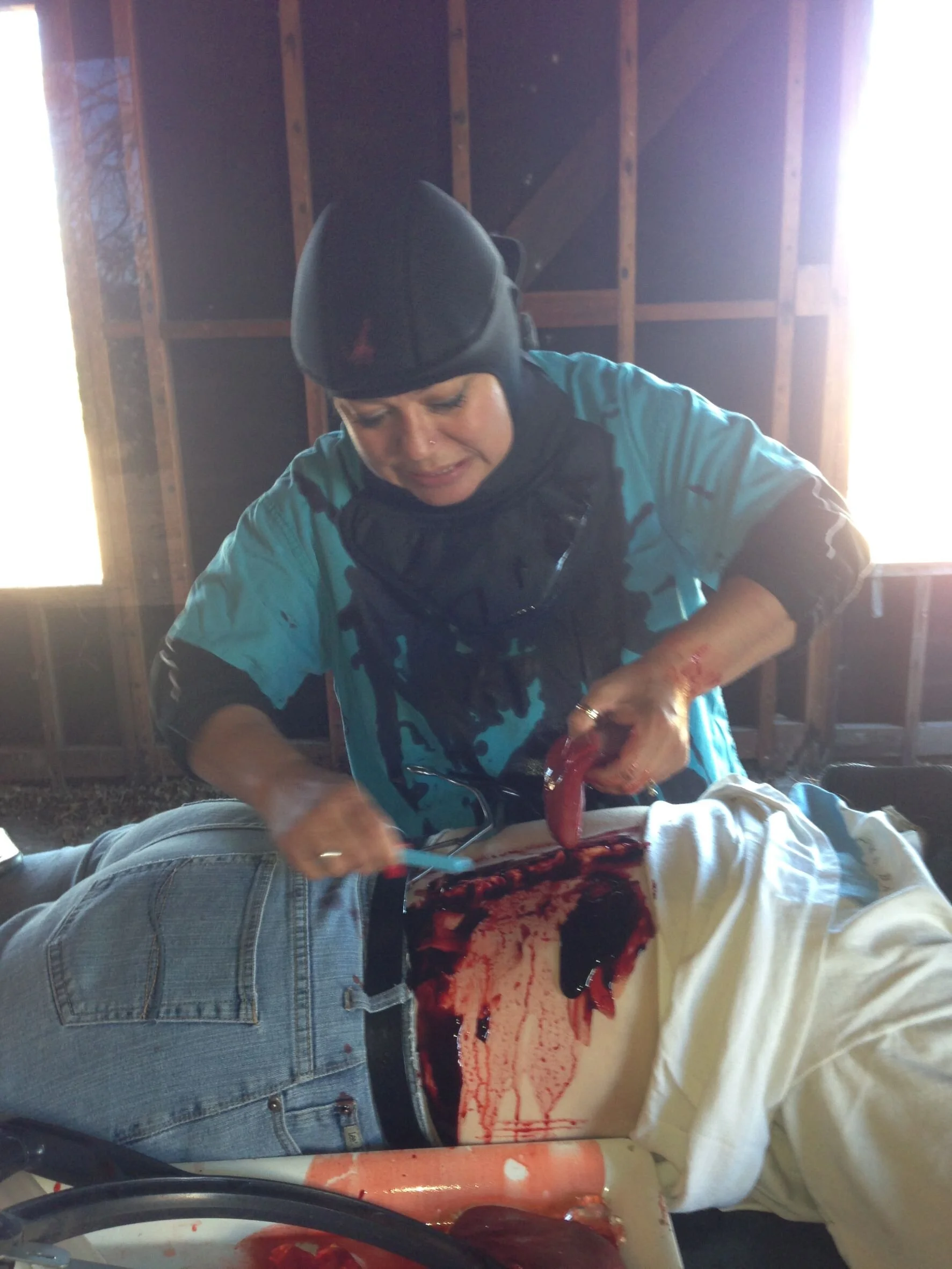 Female medic removing victim's (phony) liver during tactical medical hands-on training