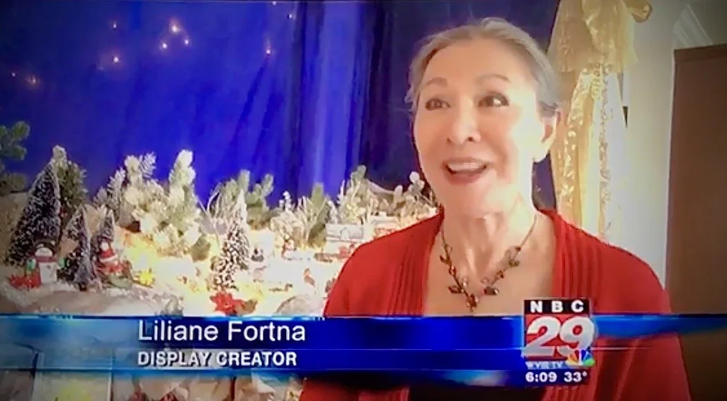 Liliane speaking in front of her Christmas display on a local TV broadcast