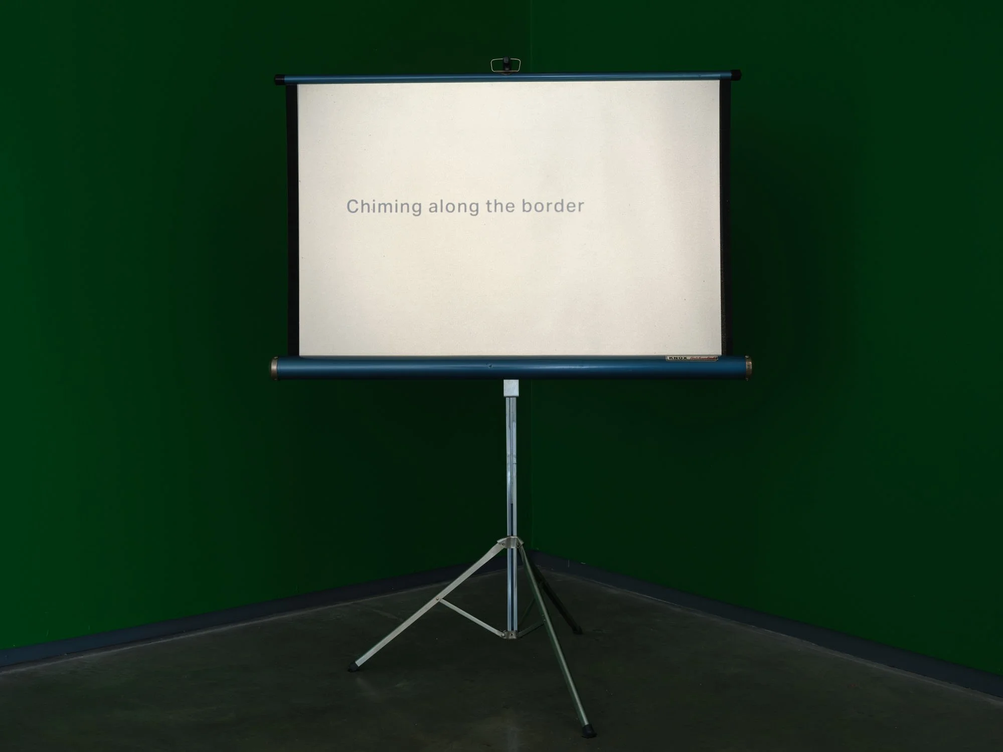 Christopher Steenson,  The Long Grass , 2022–24, 35mm slides, slide projector, vintage portable projection screen and projection table, timing system, amplifier, horn speaker, carved field stone, cabling. Dimensions variable. Duration: 5 minutes 49 s