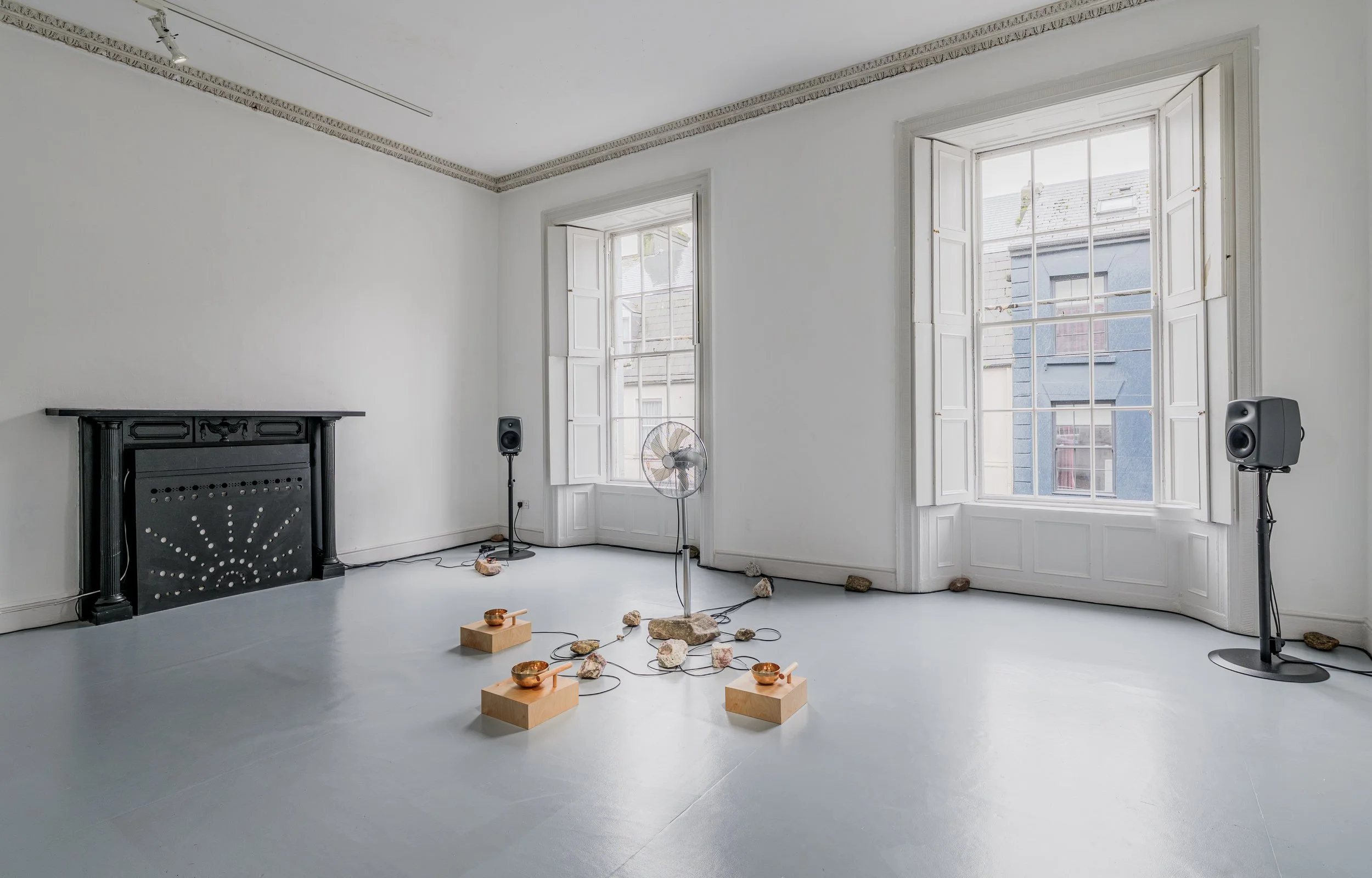  Where Does the Body End? , 2025, air quality sensor, singing bowls, chrome-plated pedestal fan, wood, carved stone, 3D-printed components, five-channel sound, custom software, Raspberry Pi microcomputers, Arduino microcontrollers, motors, circuitry,